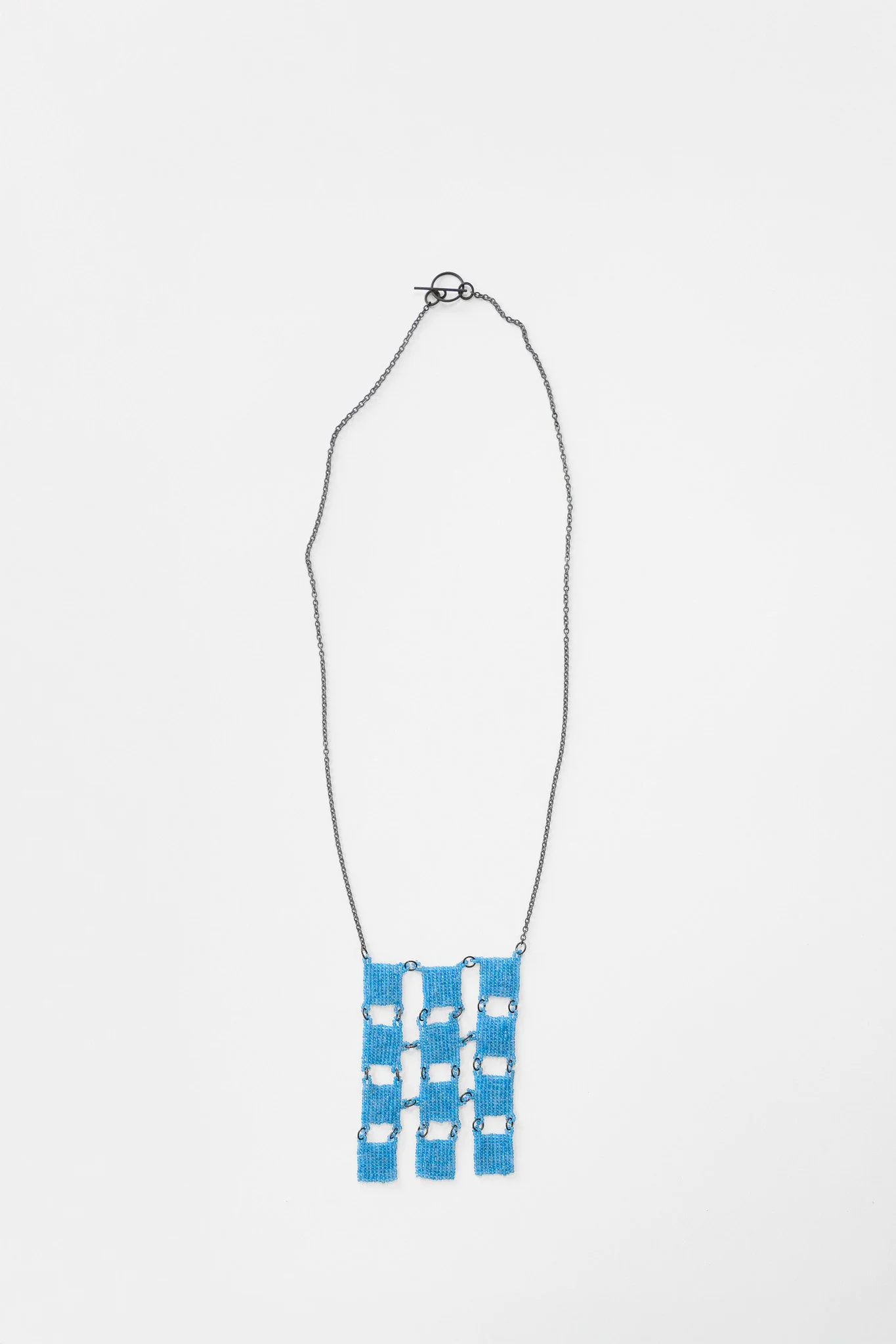 27. Mascha moje, ‘Untitled’, (12 light blue squares), 2025, oxidized mild steel, oxidized sterling silver chain, monel clasp and findings and 12 glass bead squares, pendant 6.5x9cm, chain 33cm. Price: $1,600 