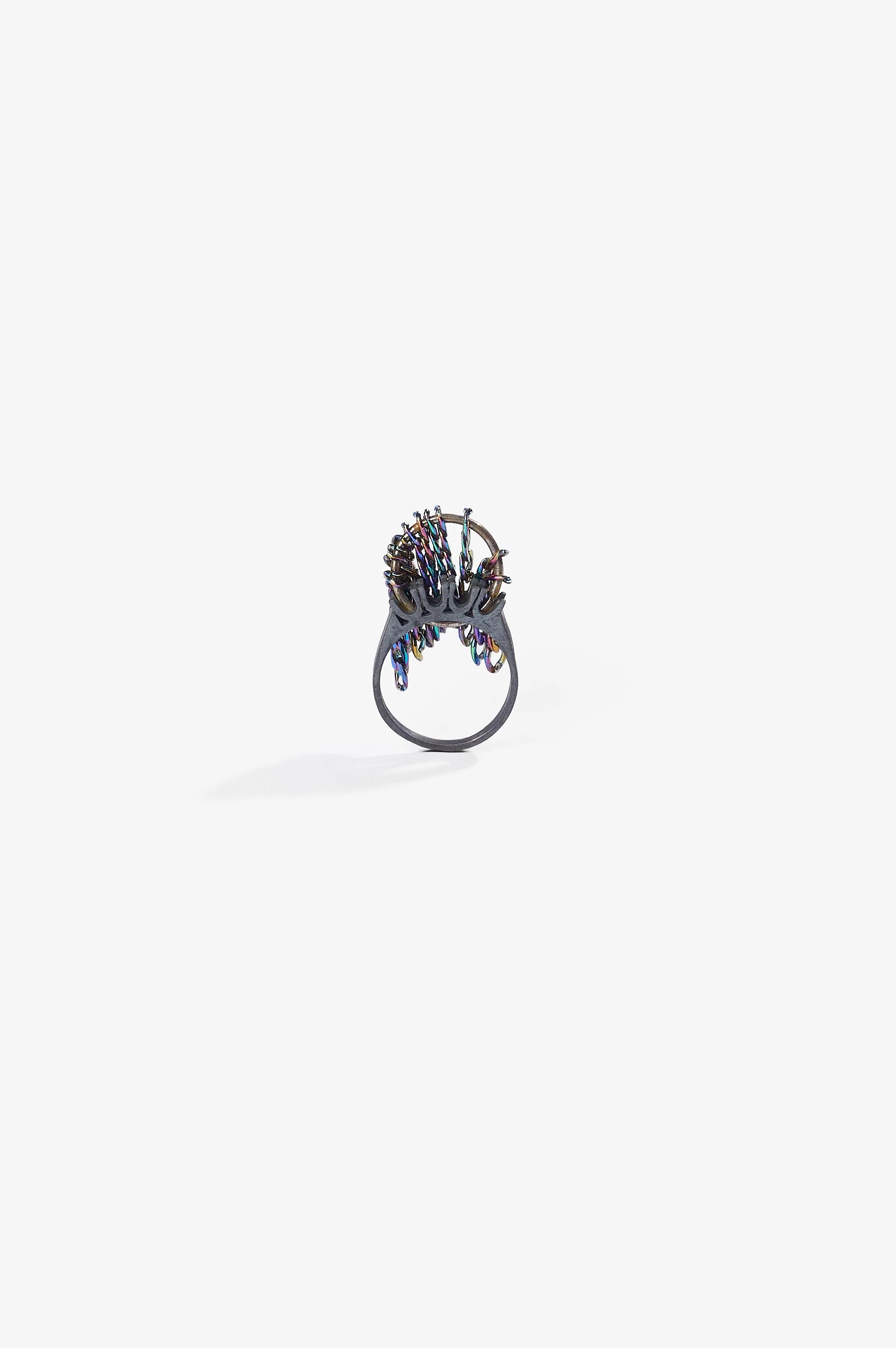 Debris Facility, Capsule Collapsing, oxidised silver, surgical stainless steel, aluminium, 3D printed nylon, anodised stainless steel, printed acetate, mirror frame, acrylic display, acrylic paint, iridescent pigment, 2026. Metal rings $365 each. Pho