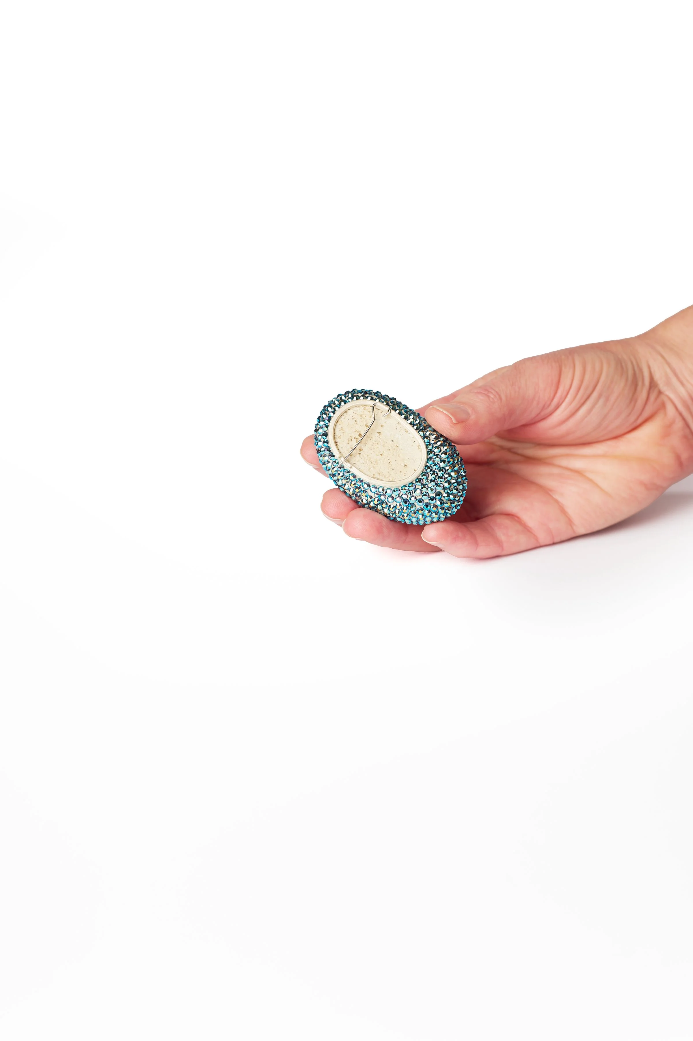 34. Raewyn Walsh, ‘lil blue’, rhinestone brooch, (oval blue), 2025, found pumice, Preciosa crystals, sterling silver, stainless steel wire, 6x2x4cm. Price: $390.