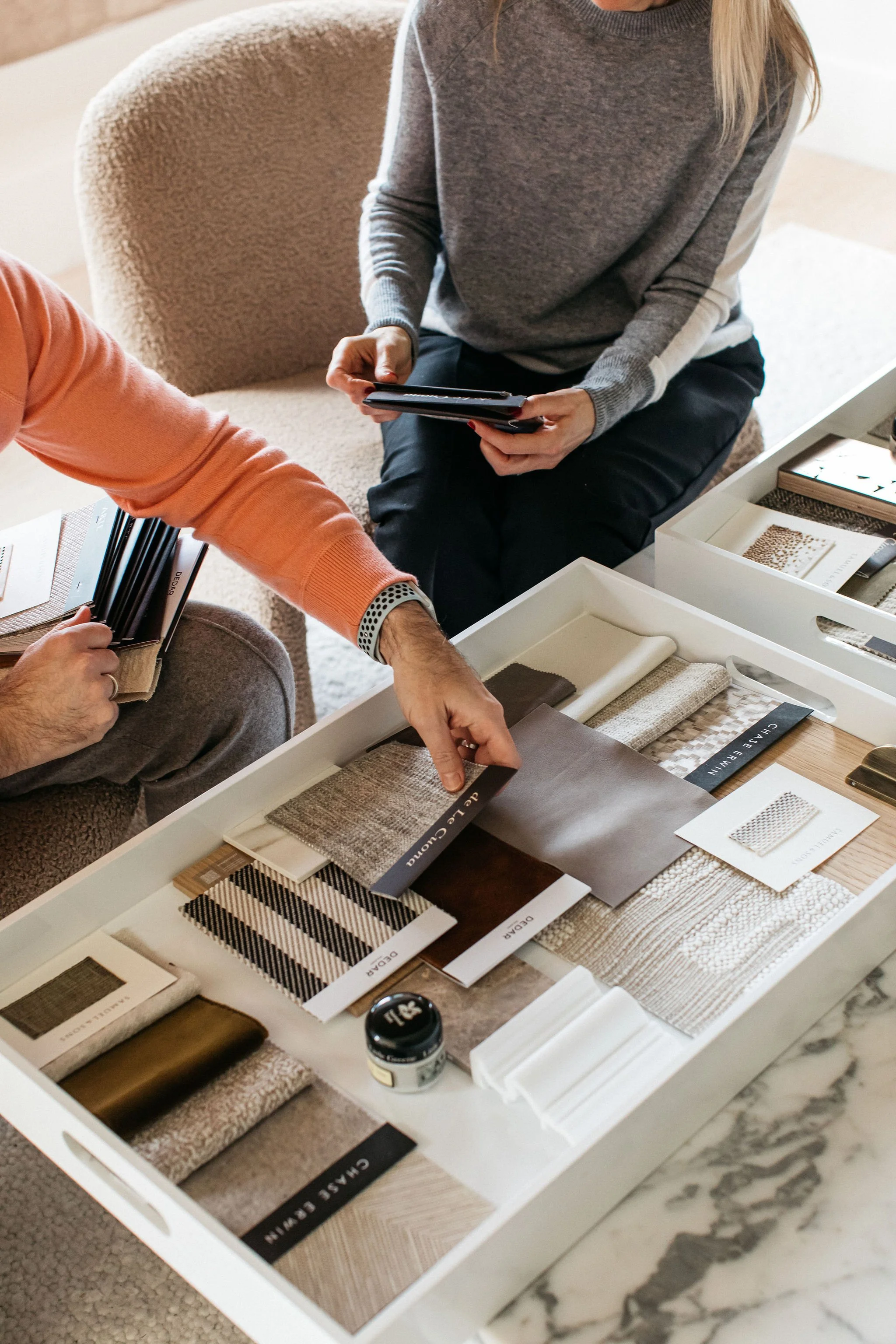 Client and interior designer in consultation reviewing moodboards and documents, discussing key questions to ask an interior designer.