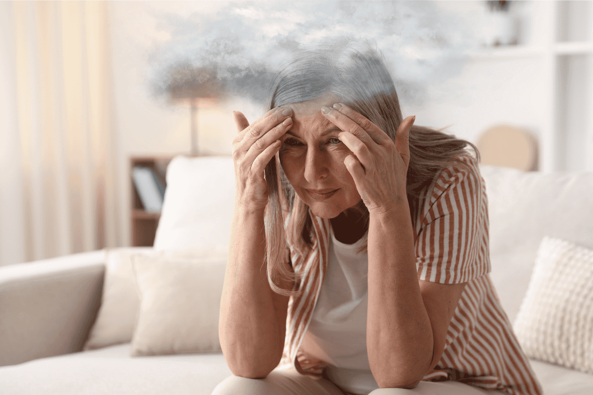 Woman sat on sofa struggling with brain fog