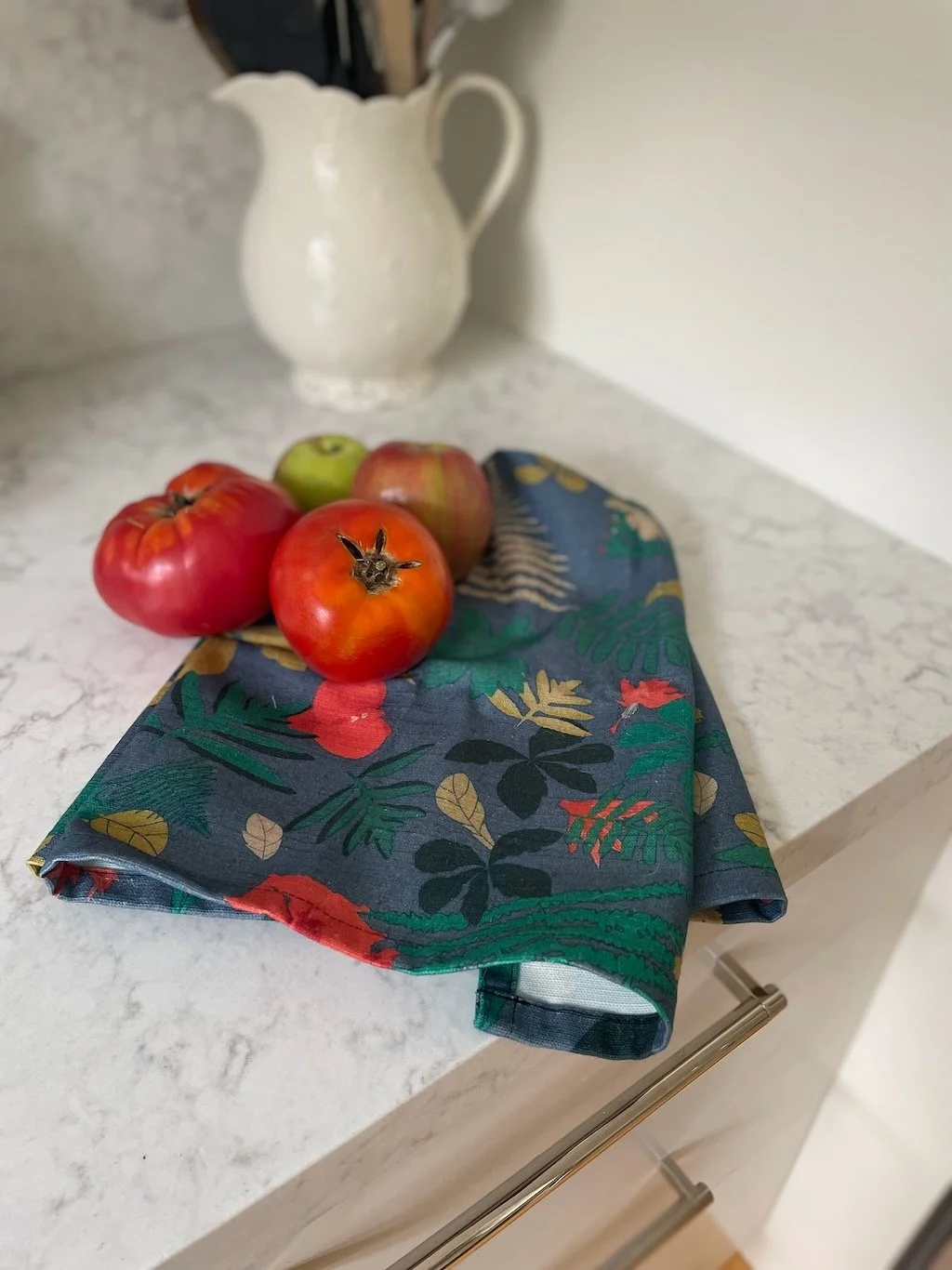 Green and red tea towel on white kitchen counter