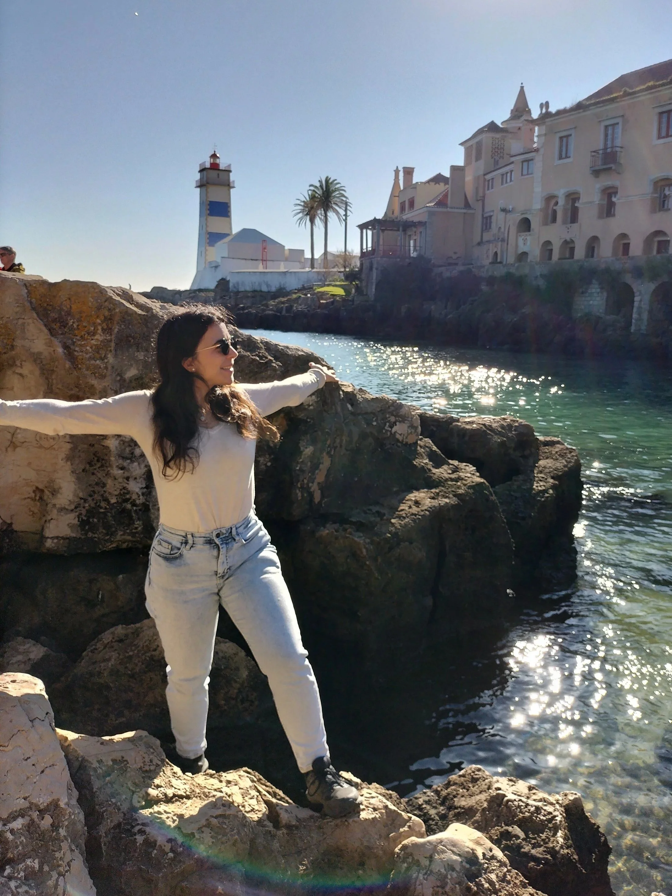 Professional coach standing near a lighthouse in Cascais, Portugal, symbolizing guidance and personal growth