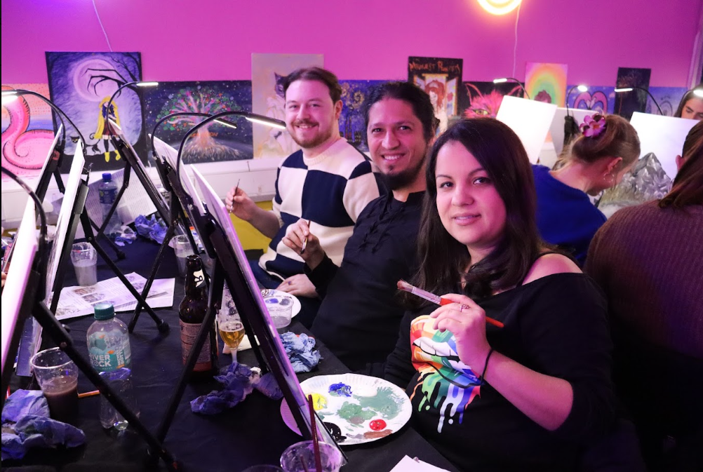 People posing with paintbrushes and canvas