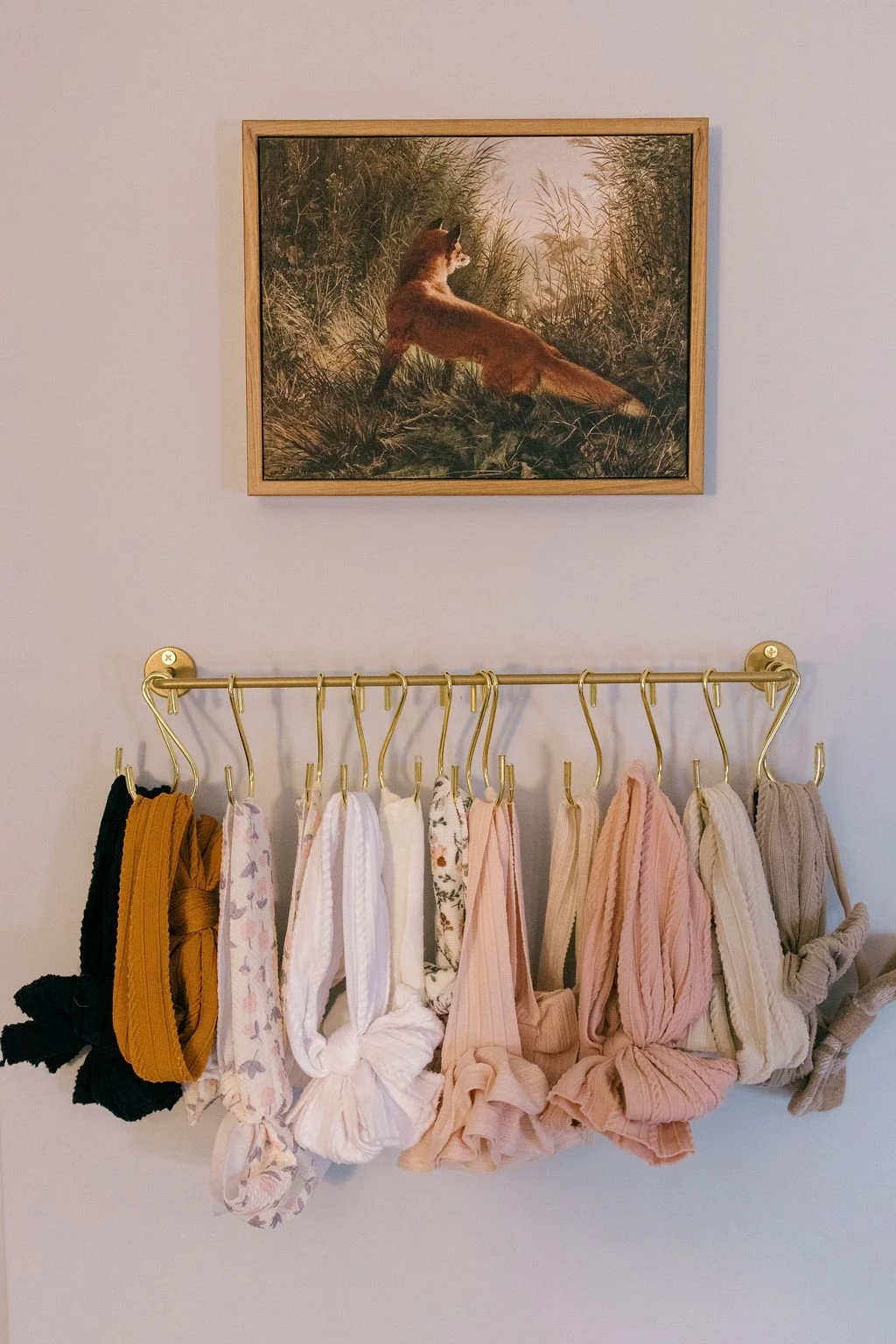  Soft baby bows hanging on a nursery wall, photographed as part of a documentary family session in Sterling, Virginia. 
