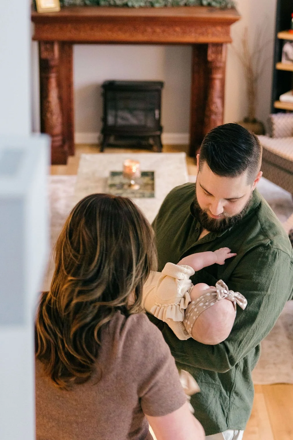 Father holding his baby in the main entryway of the home during a documentary family photography session in Sterling, Virginia. 