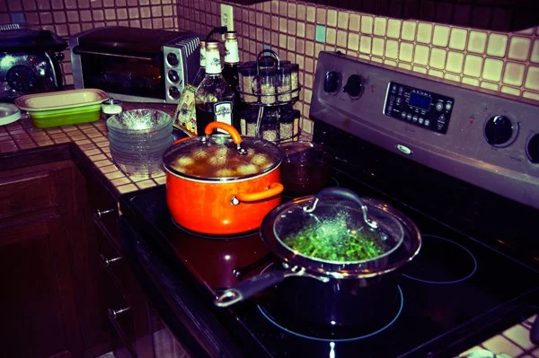 Two pots simmering on a stove during Passover seder meal preparation, captured candidly behind the scenes by documentary family photographer Mel Usry Photography Northern Virginia.