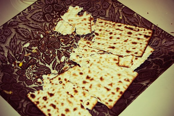 Broken pieces of matza on a decorative plate at a Passover seder, documented as part of a multi-generational family gathering by Mel Usry Photography Northern Virginia.