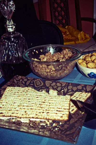 A bowl of charoset, a plate of matza, and a bowl of soup nuts on the Passover seder table, documented as traditional holiday food details by Mel Usry Photography Northern Virginia.