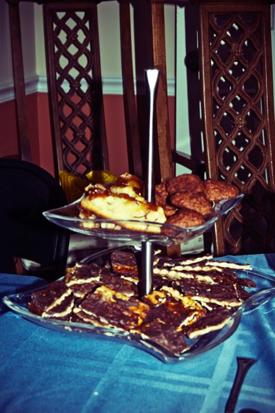 A two-tiered dessert stand filled with Passover cookies and chocolate bark displayed on the seder table, documented as a holiday food detail by Mel Usry Photography Northern Virginia.