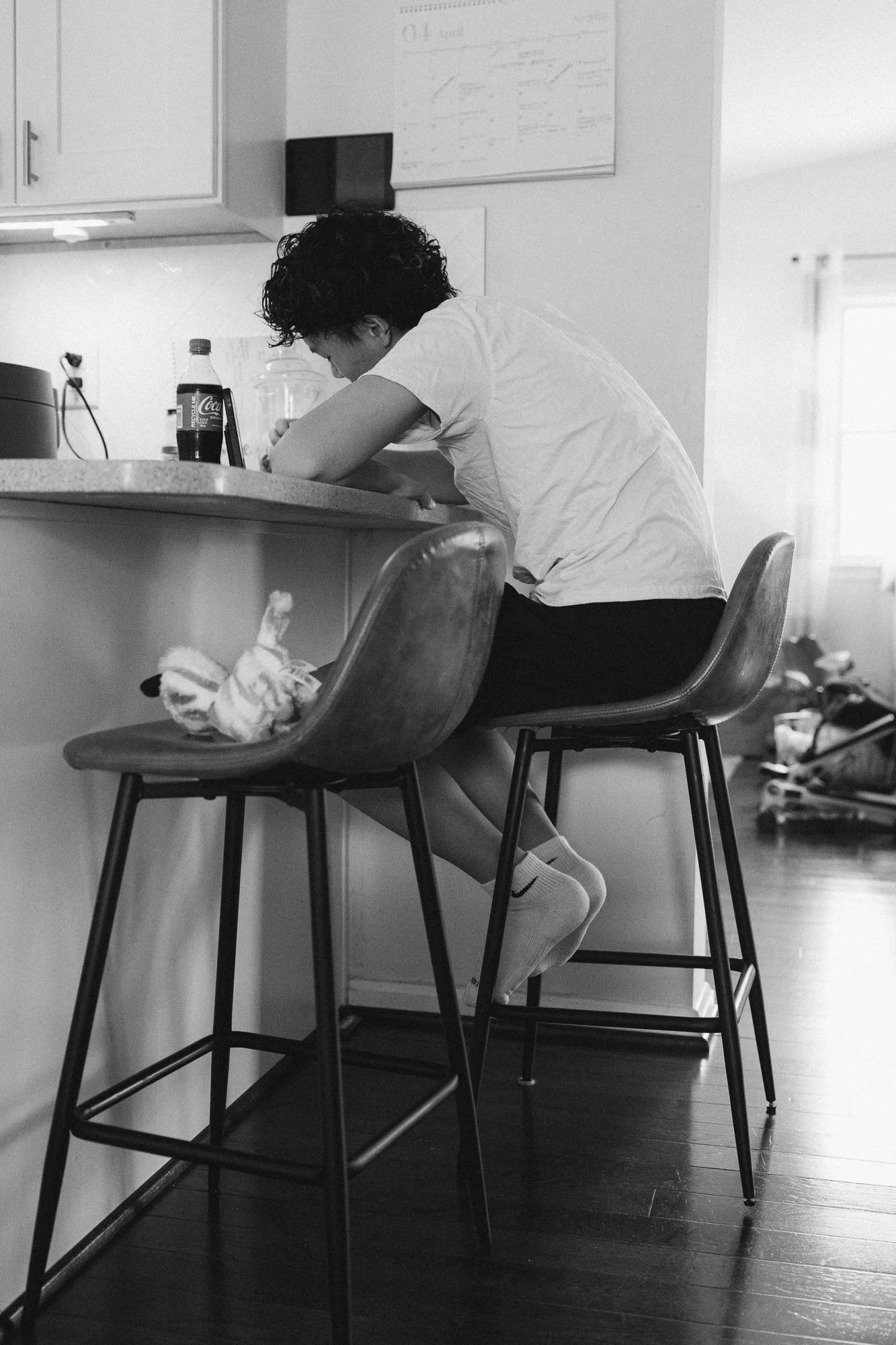 Teenage boy sitting at the kitchen counter at home, candid moment captured during a day in the life family session by Mel Usry Photography, Northern Virginia
