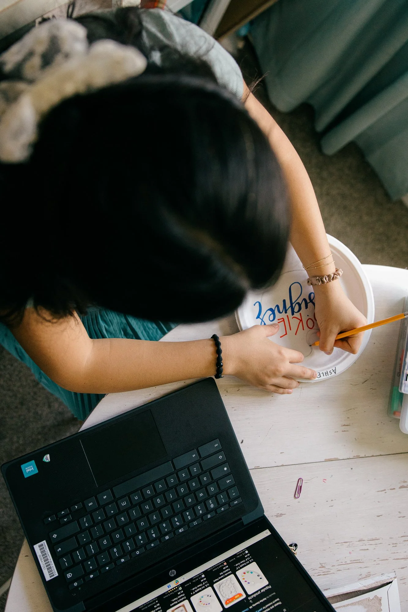 Close-up of teenage girl working on a craft project at home, an ordinary moment captured by documentary family photographer Mel Usry Photography, Northern Virginia