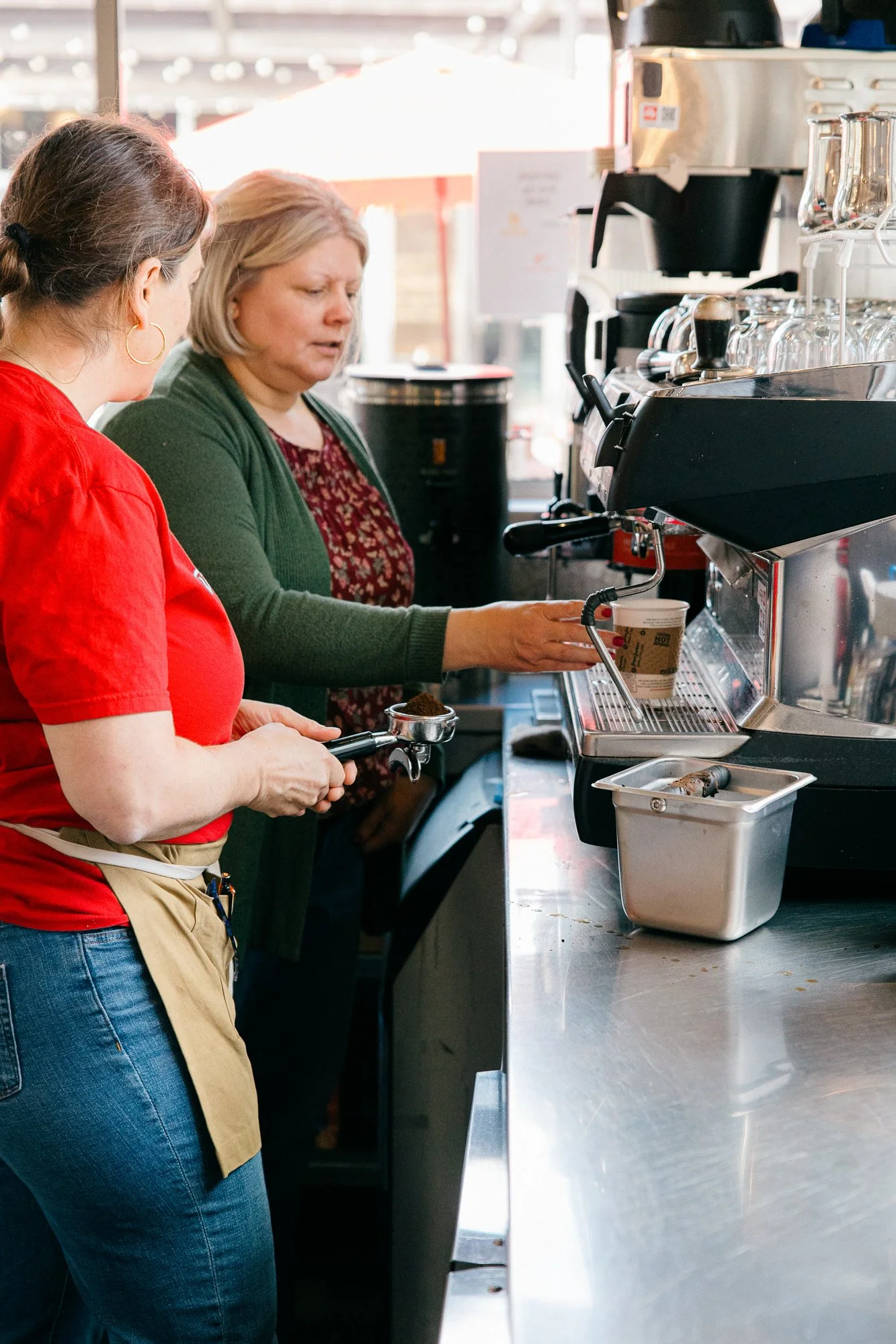 Two staff members work together at the espresso machine at Urbano Modern Italian restaurant, captured candidly during a documentary brand story session by Mel Usry Photography in Sterling, Virginia.