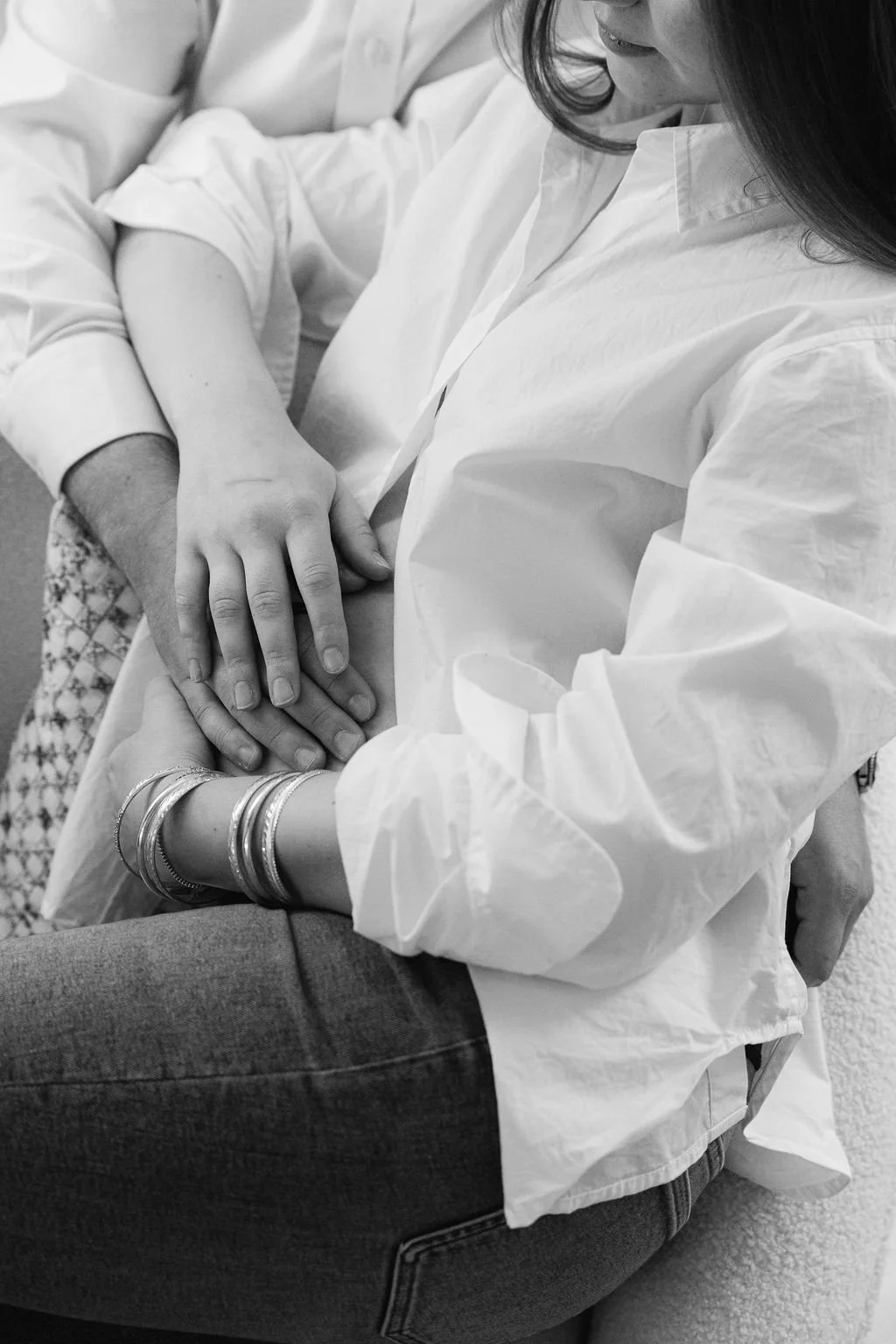Pregnant couple holding hands on baby bump during an intimate maternity session in Alexandria, Virginia.