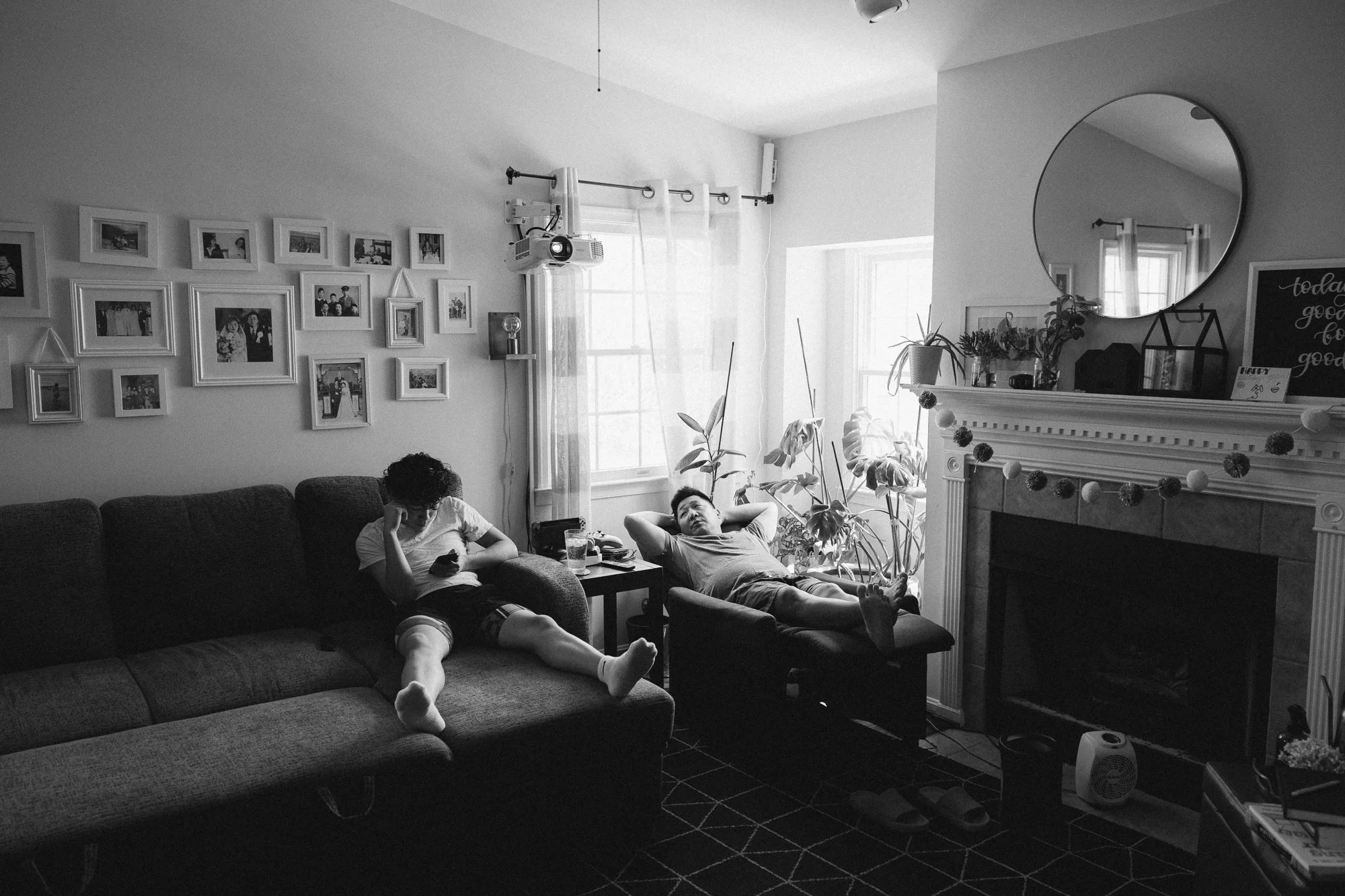 Father and teenage son relaxing in their living room on their phones, captured during a documentary family photography session by Mel Usry Photography, Northern Virginia