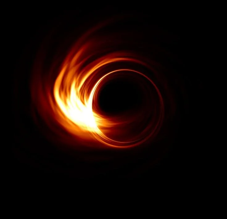 Un trou noir entouré d'une accrétion de matière brillante et lumineuse, formant un accrétion spirale avec des teintes de rouge, orange et jaune dans un espace sombre.