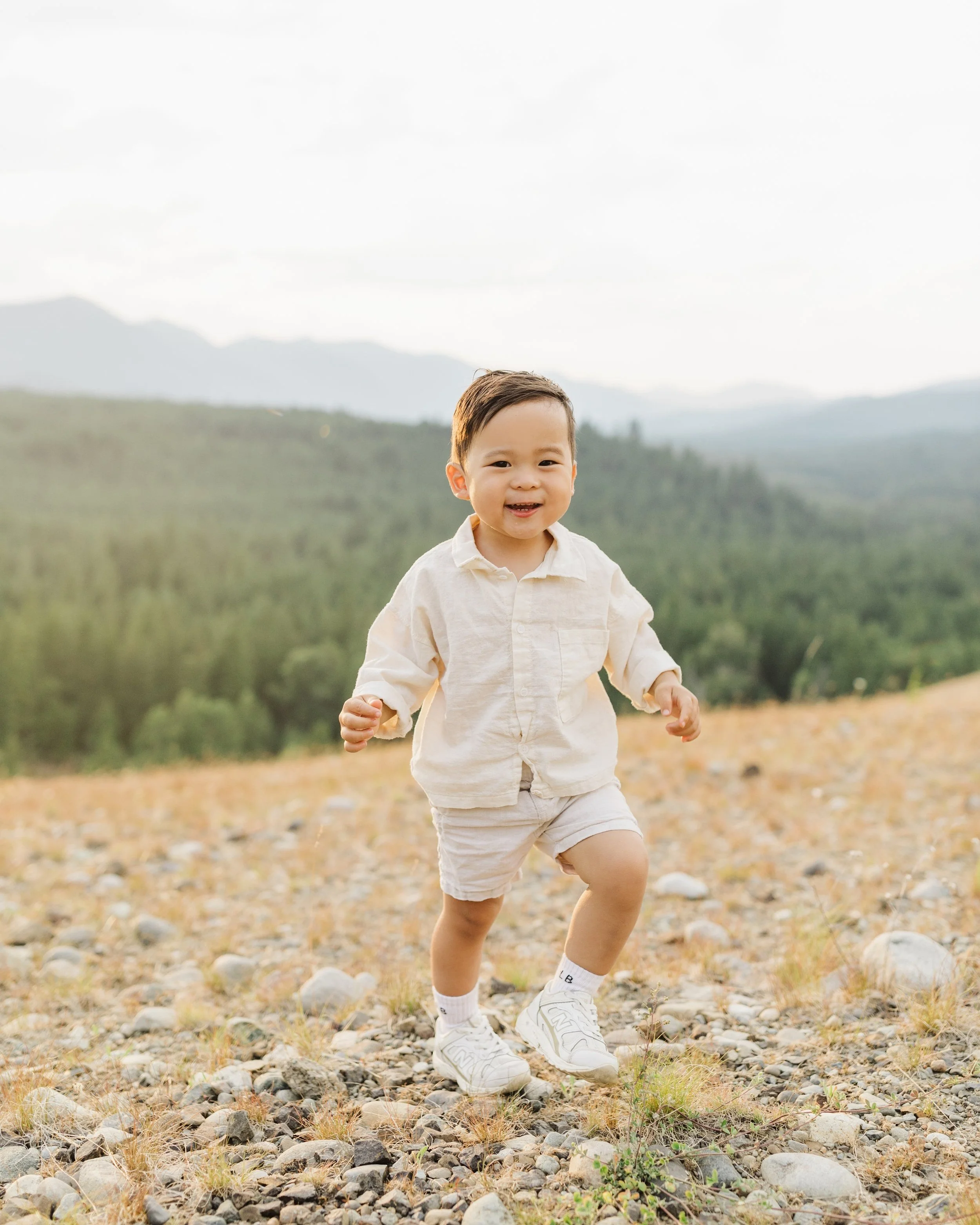 baby boy smiling walking up a hill