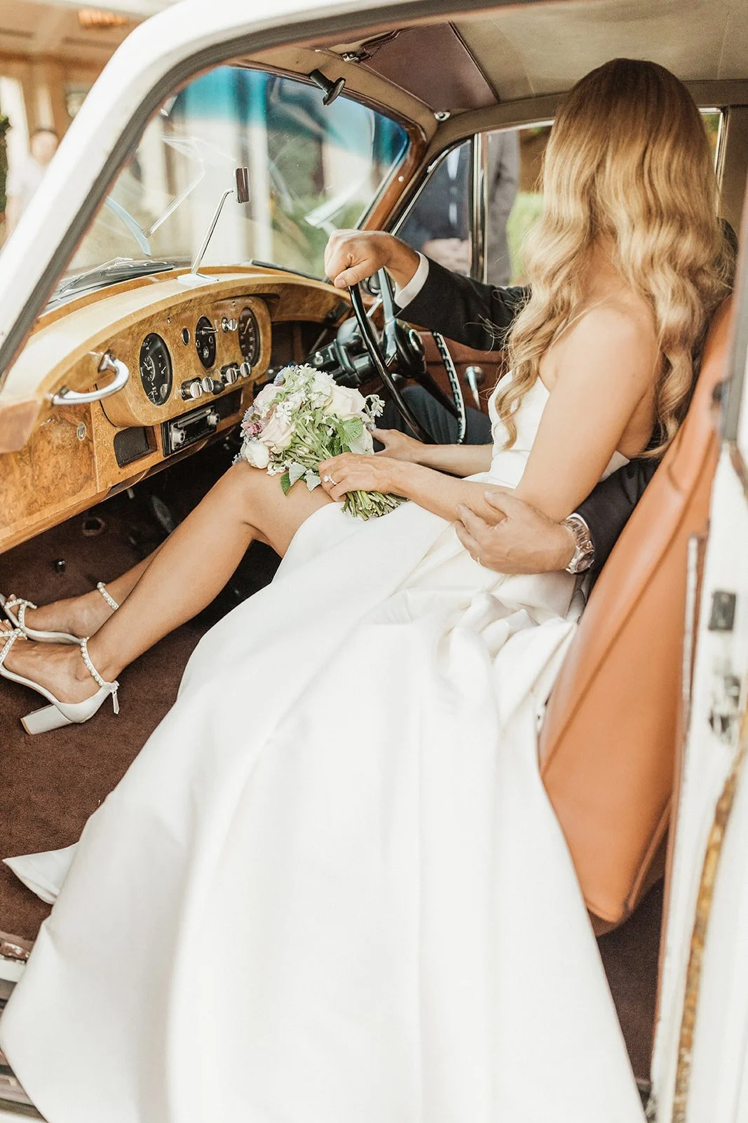 newlywed couple sitting in classic car