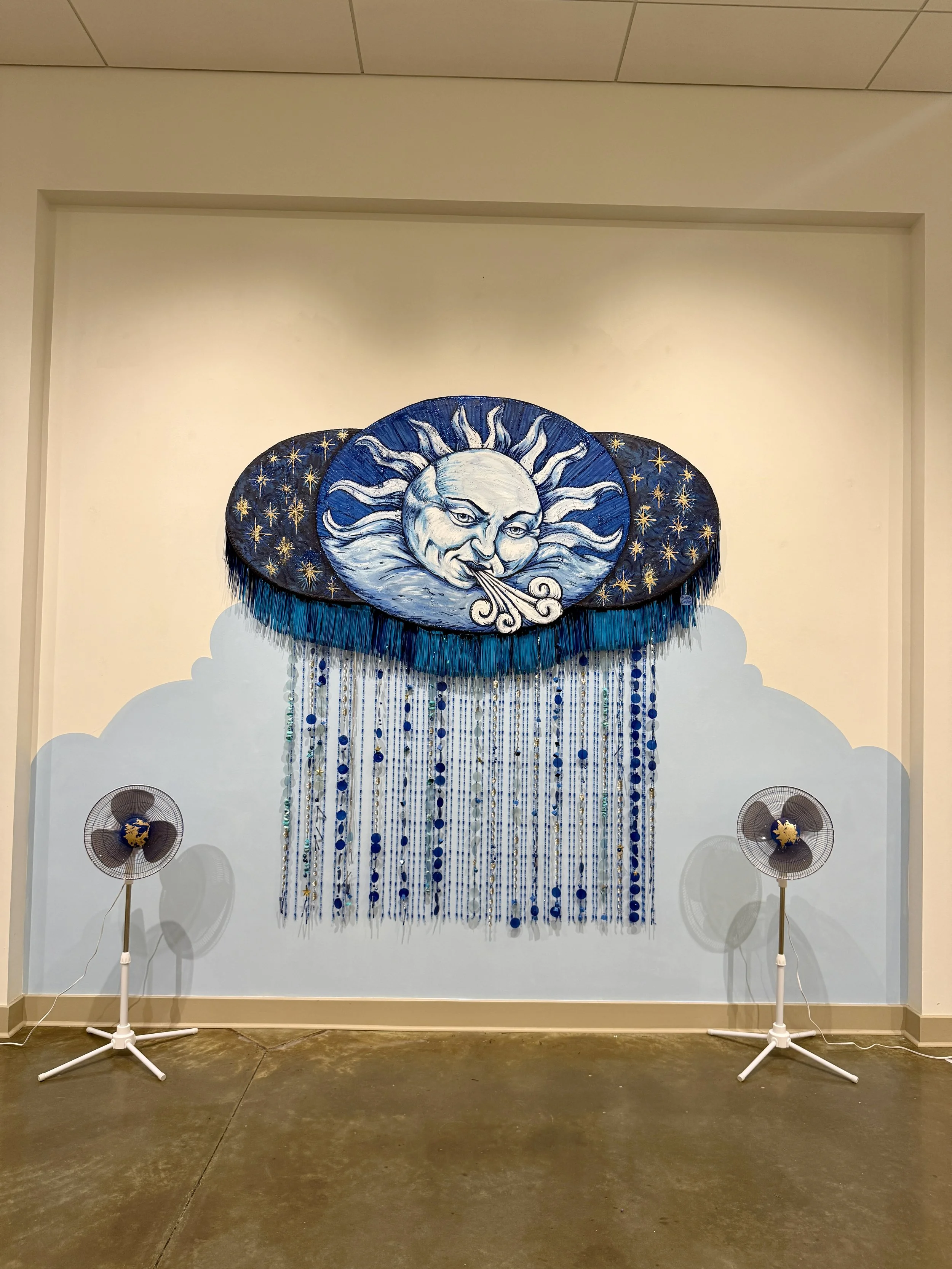 Interactive sculpture by Banks Compton for Color + Sound II, featuring a painted wind-and-sun form with hanging chimes, beads, shells, and found objects.