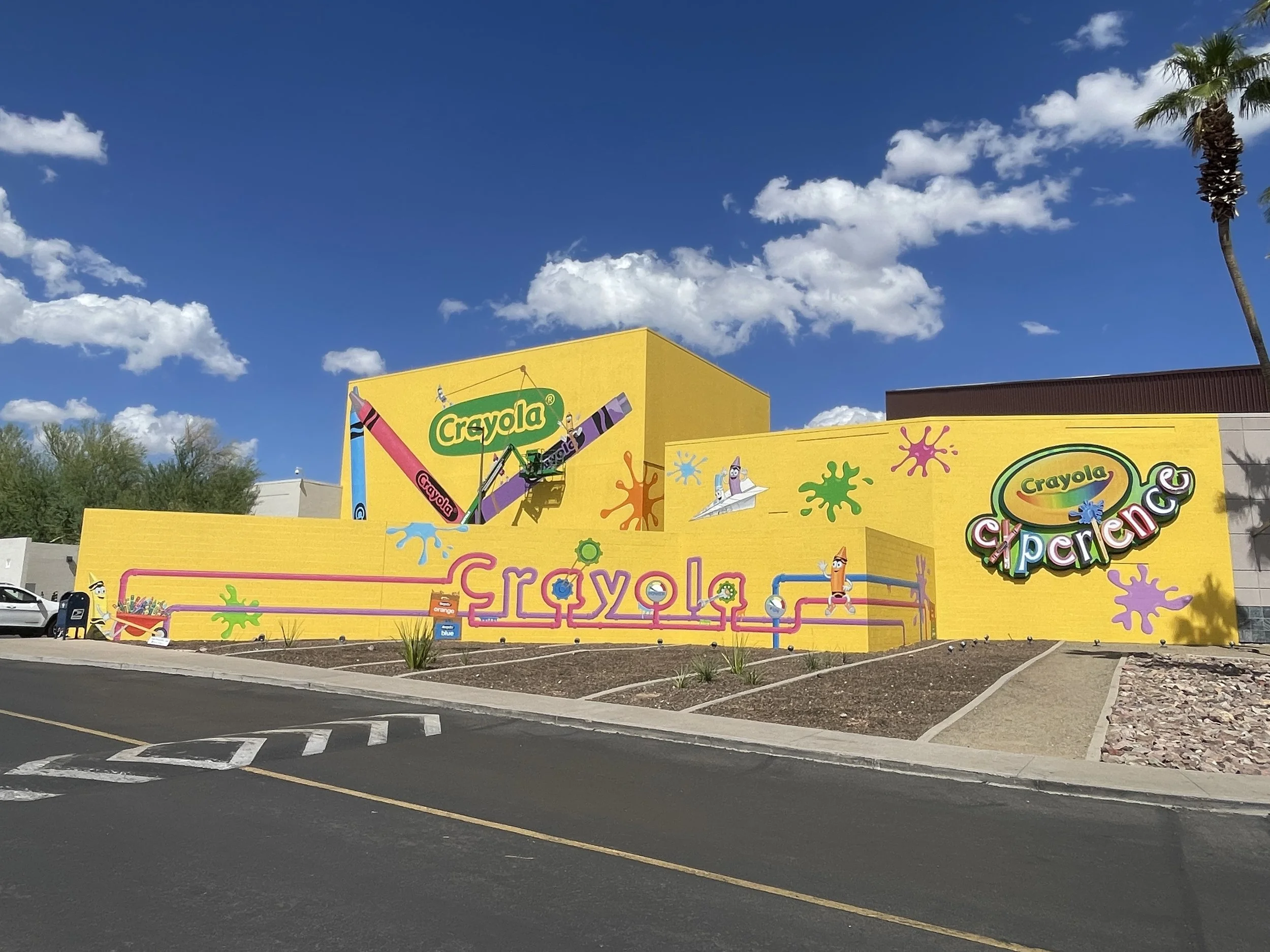 Exterior Crayola Experience murals in Chandler, Arizona, restored by Banks Compton while assisting lead artist Taylor Nelson.