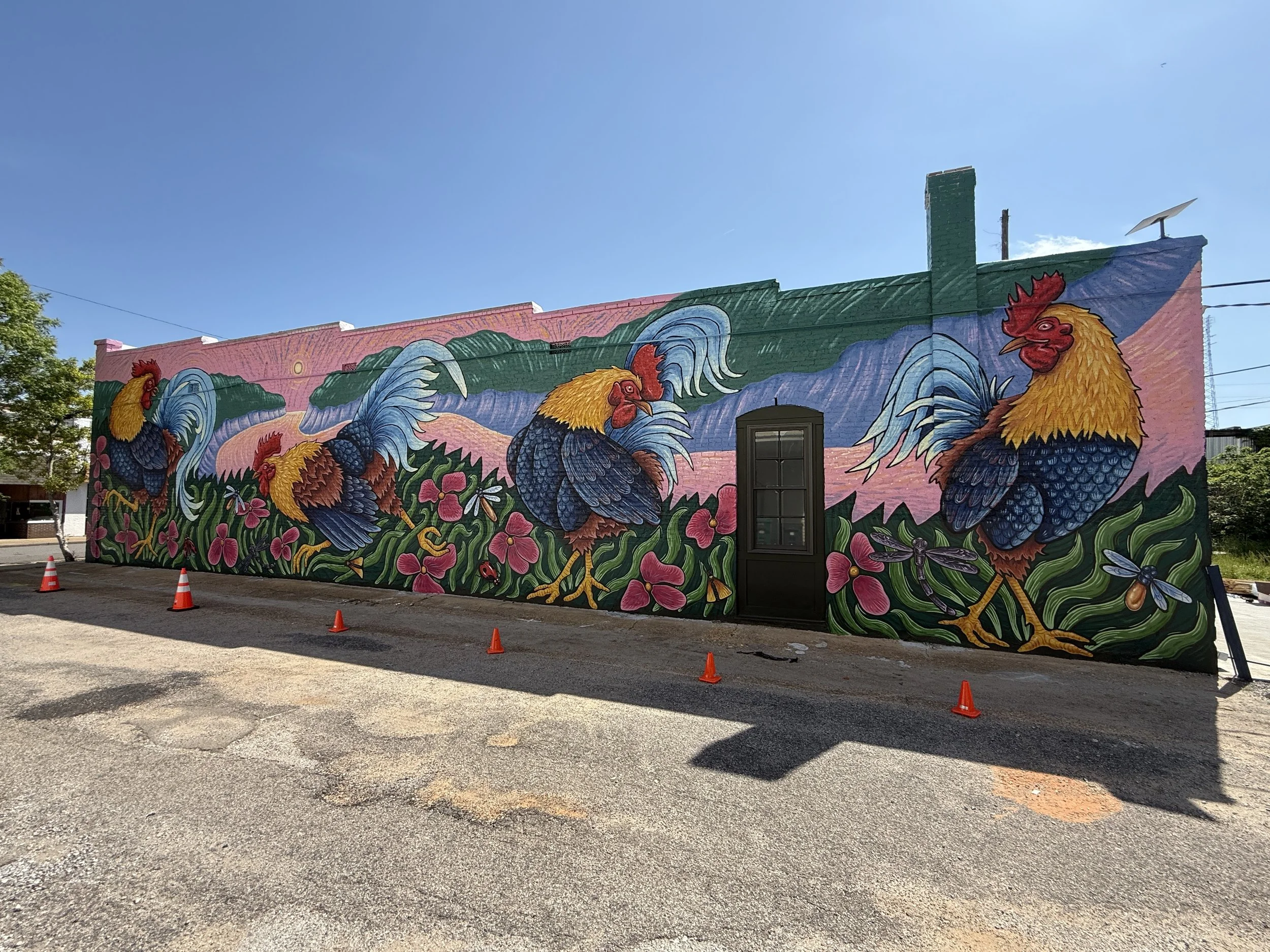Rooster Day mural by Banks Compton at the Chanticleer Center in downtown Demopolis, Alabama, featuring four colorful roosters, flowers, and local landscape imagery.