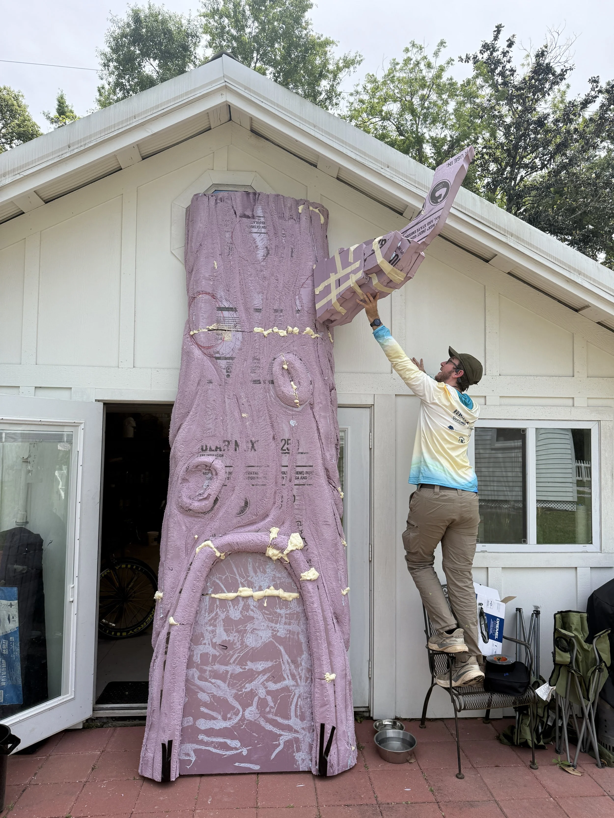 Banks Compton constructing the Foley Community Library reading tree from carved foam before installation and finishing.