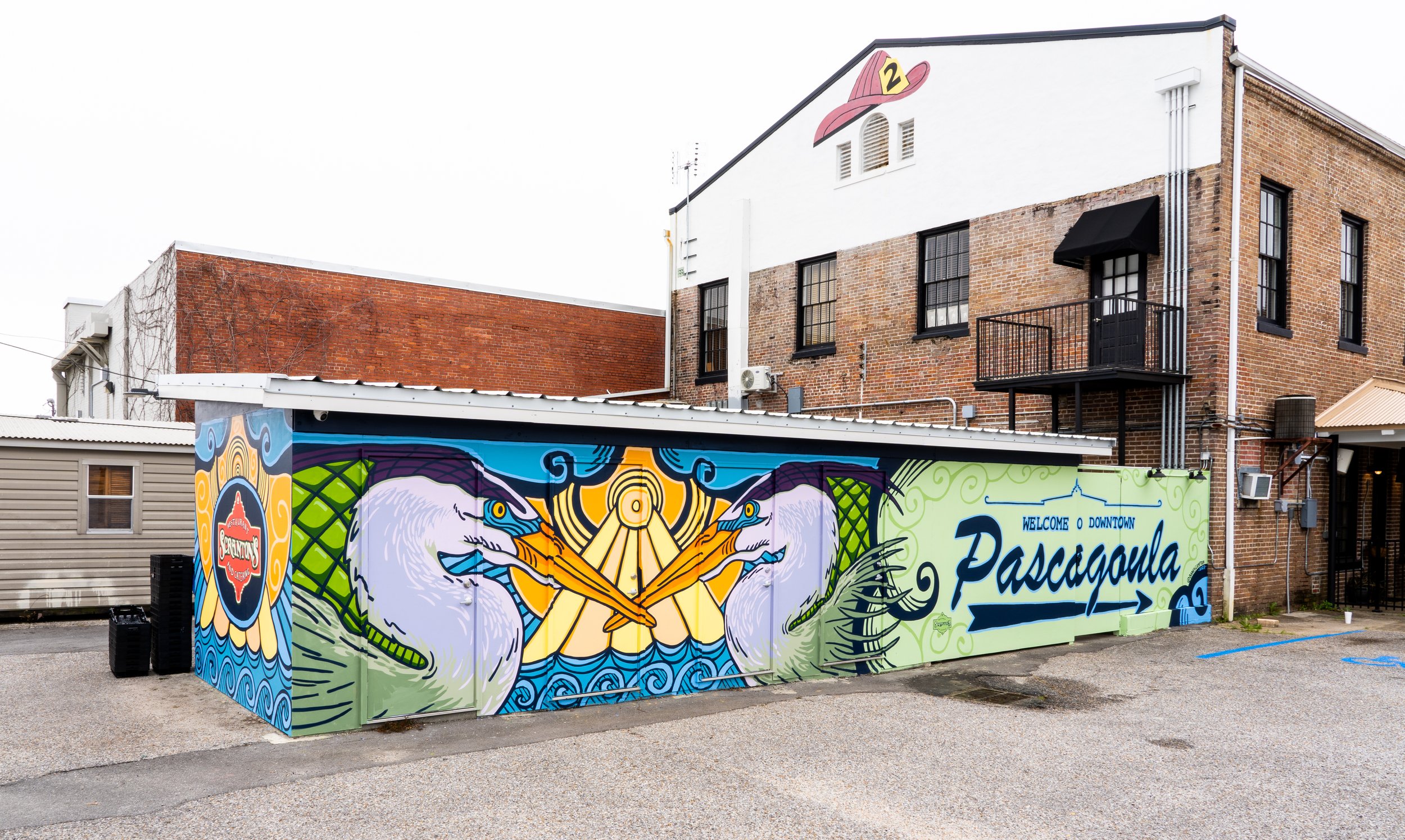 Coastal mural by Banks Compton at Scranton's Restaurant in Pascagoula, Mississippi, featuring great blue herons and a downtown welcome sign.
