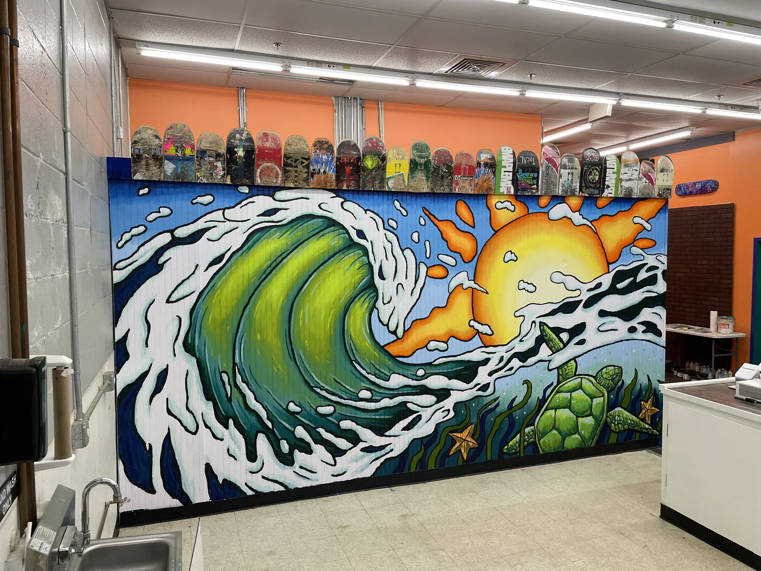 Colorful Gulf Shores mural by Banks Compton at Tambo's Surf Shack featuring a breaking wave, sunset, sea turtle, and coastal imagery.