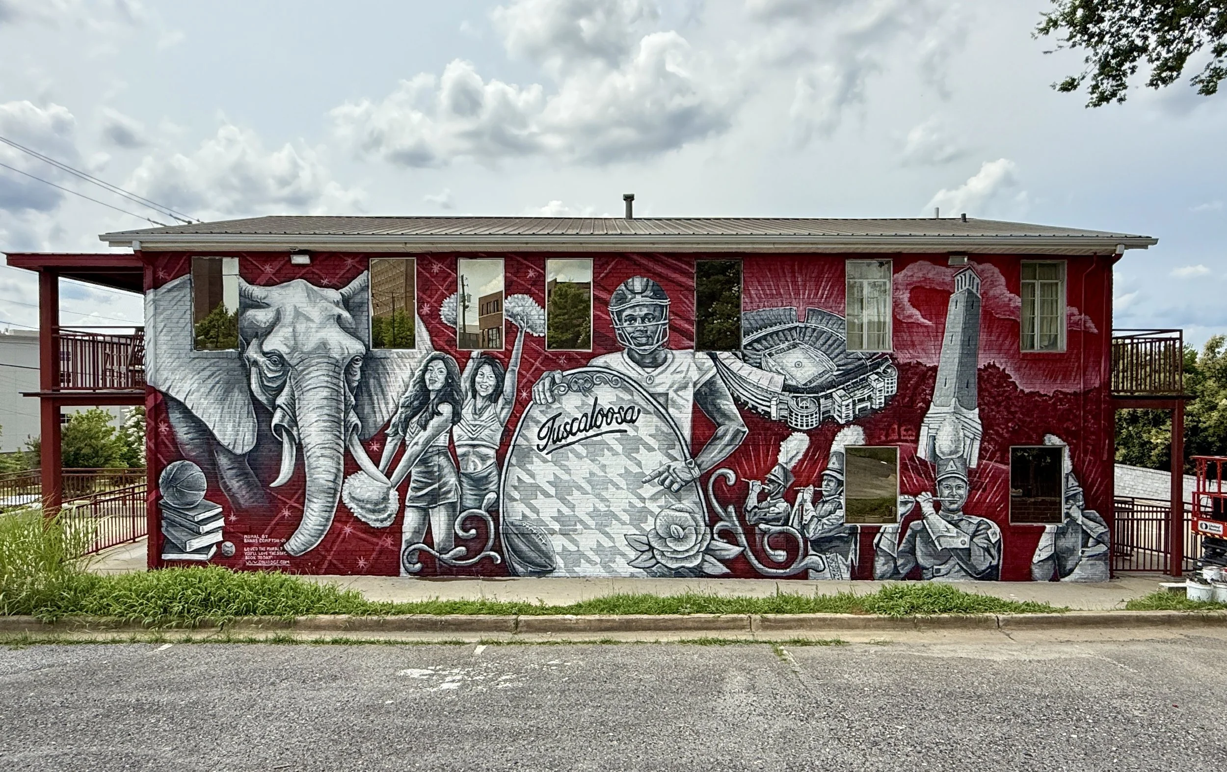 Large-scale crimson and white mural by Banks Compton in Tuscaloosa celebrating Alabama football, campus landmarks, cheerleaders, and game-day culture.
