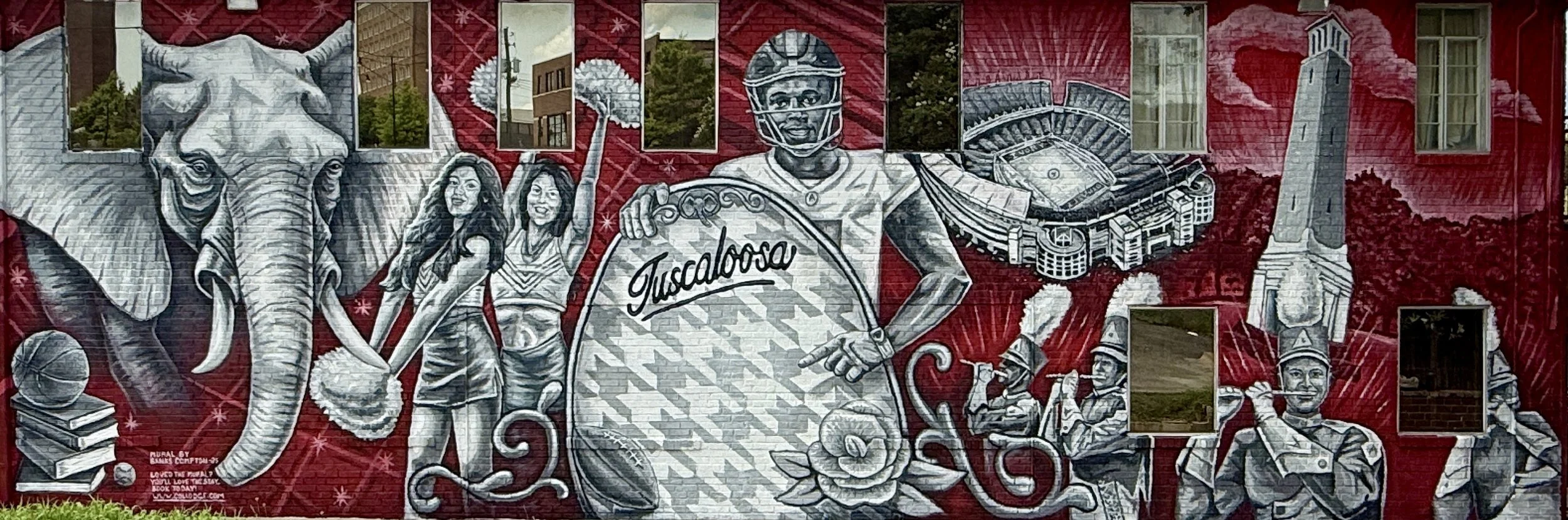 Colorful mural mural depicting elements of Tuscaloosa, Alabama, including an elephant, smiling girls, a football player, a stadium, a lighthouse, and a band member, with the word 'Tuscaloosa' written on a sign.