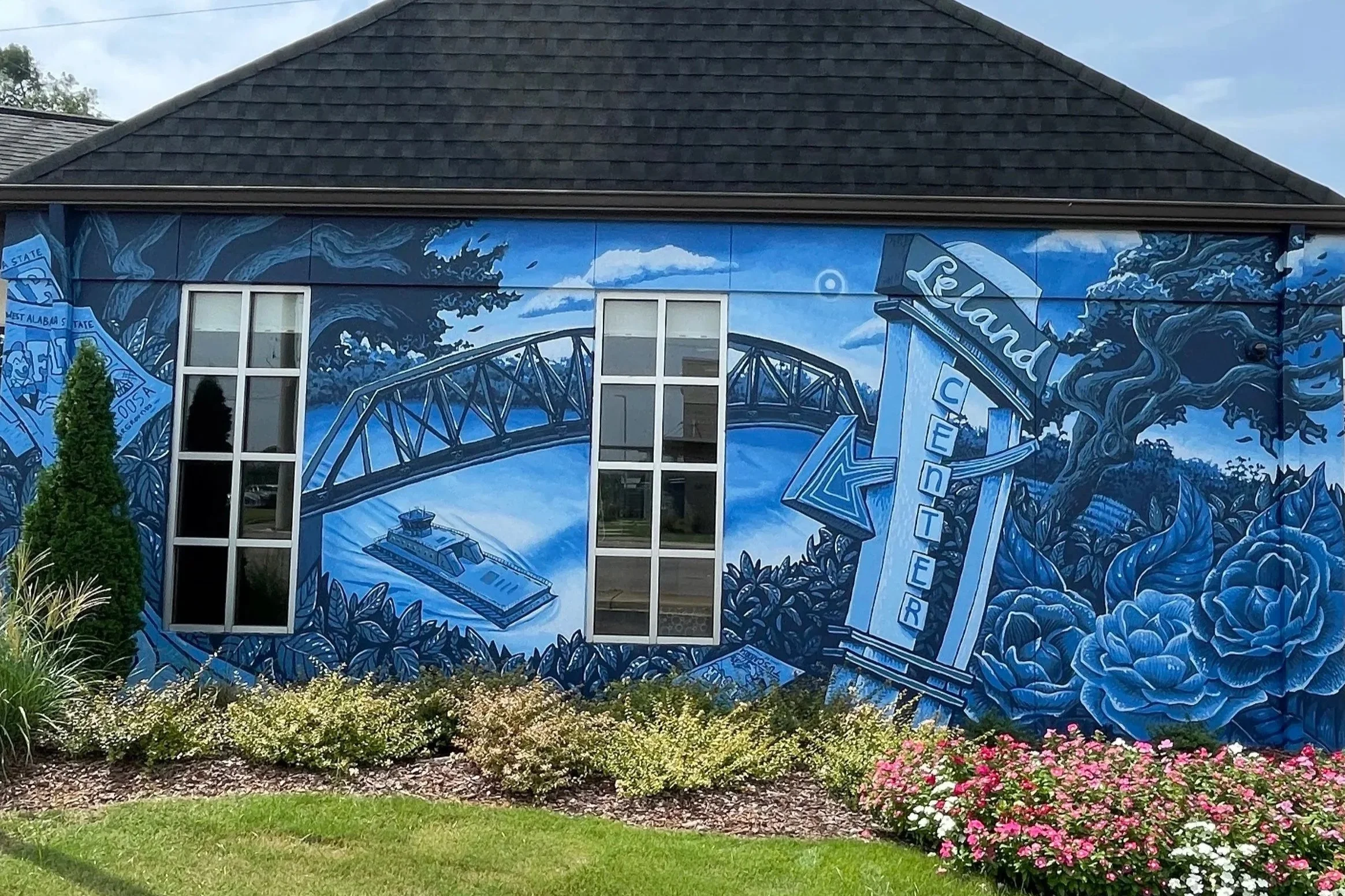 Alabama ONE Credit Union mural by Banks Compton in Alberta City, Tuscaloosa, featuring the Black Warrior River, historic landmarks, local imagery, and blue camellias.