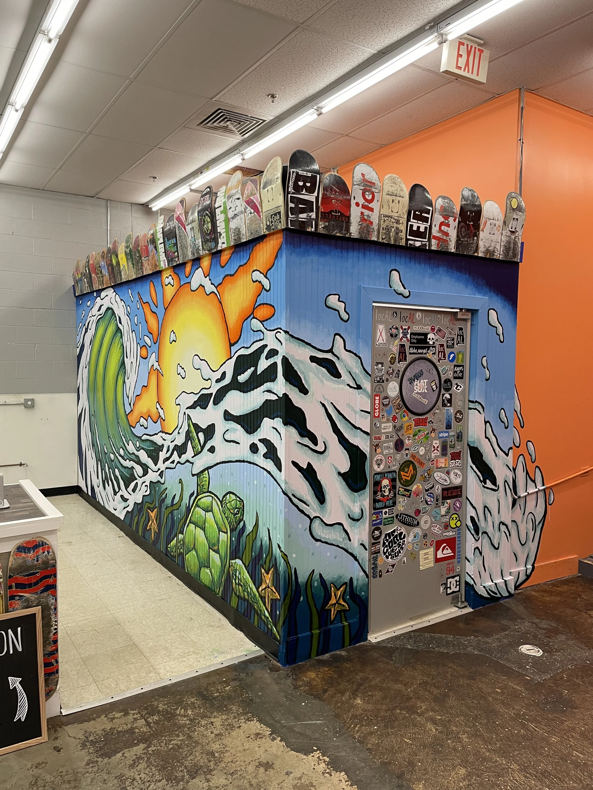 Interior surf mural wrapping around a wall at Tambo's Surf Shack in Gulf Shores, Alabama, with waves, sunset, and sea turtle imagery.