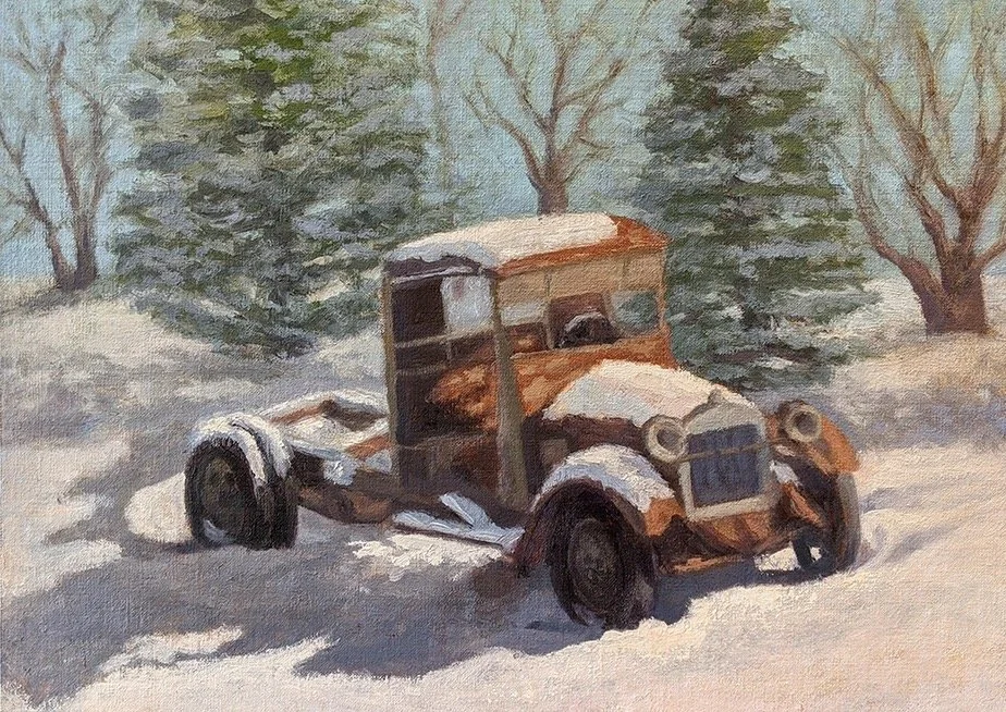 Rusty old car covered in snow among trees