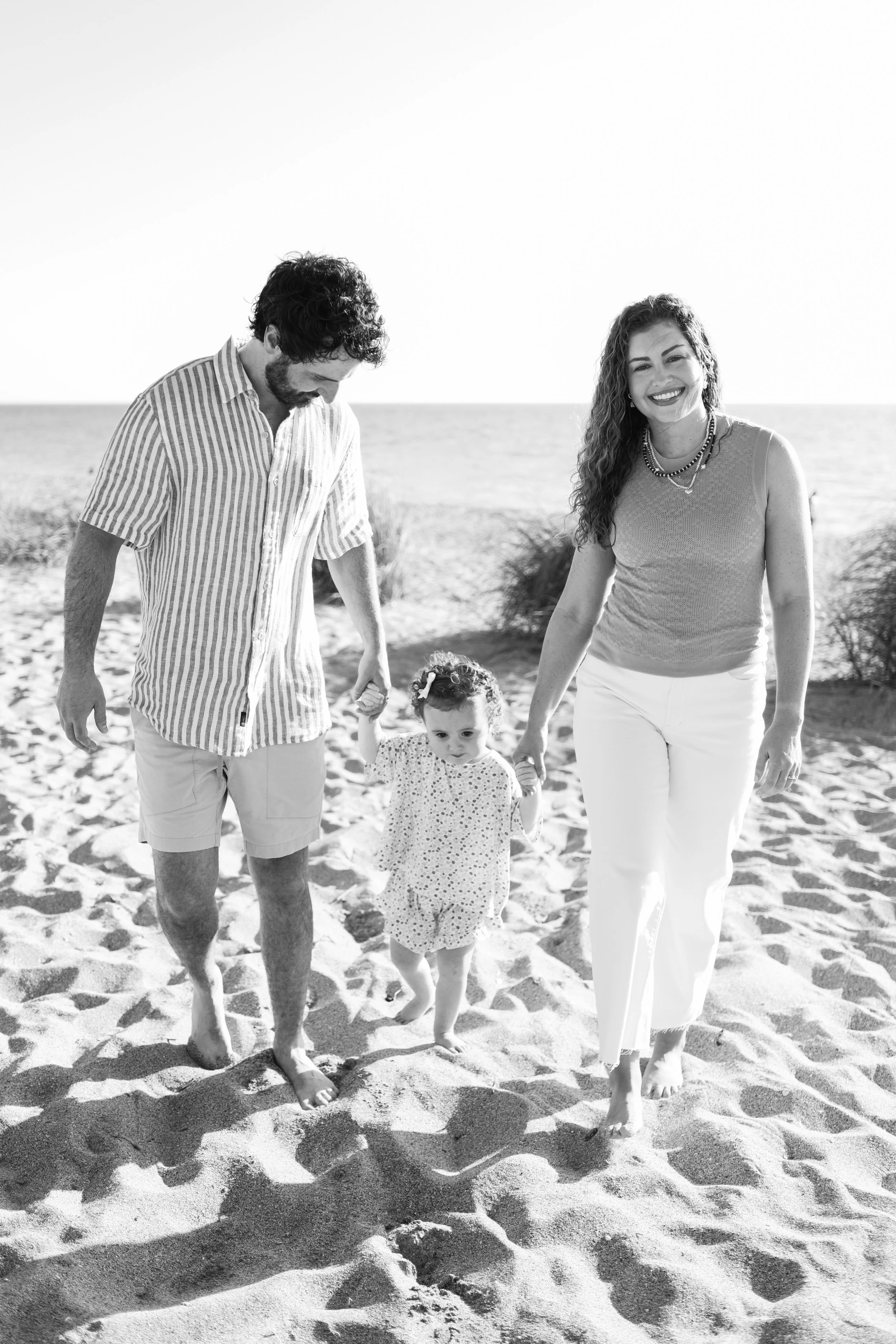 family-beach-photoshoot-venice-florida-walking-holding-toddler-black-and-white.jpg