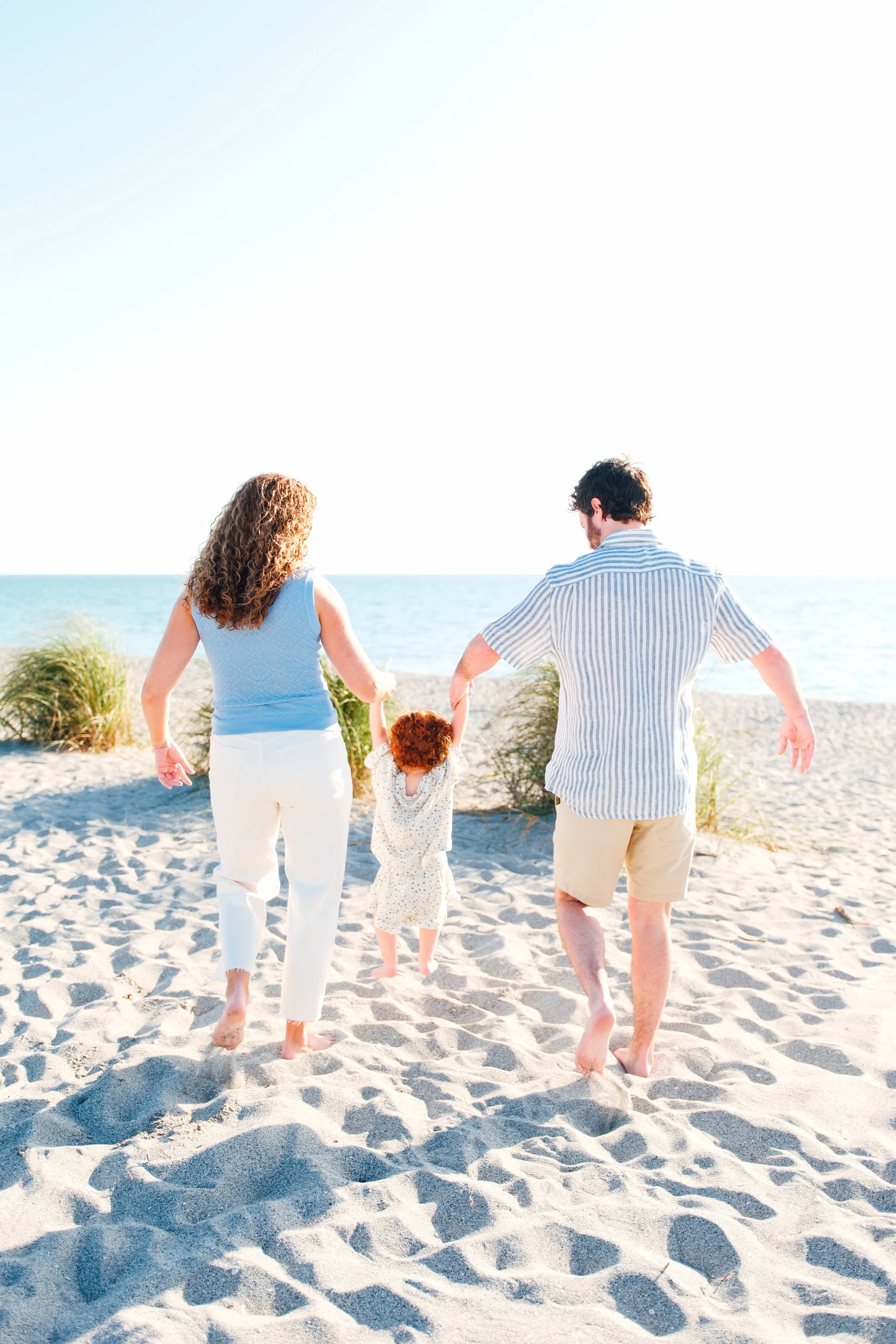 family-beach-photoshoot-venice-florida-walking-swinging-toddler.jpg