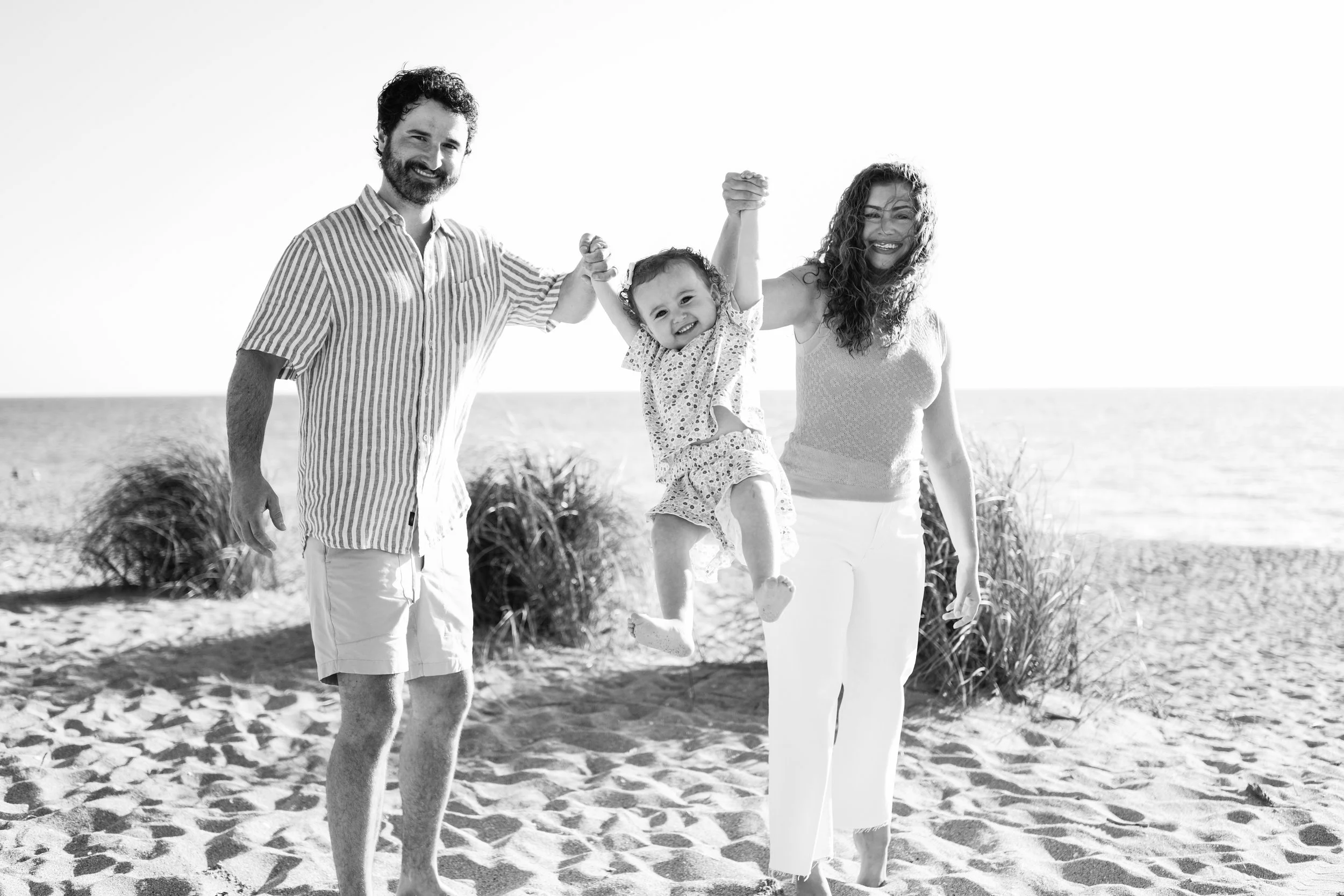 family-beach-photoshoot-venice-florida-walking-swinging-toddler-black-and-white2.jpg