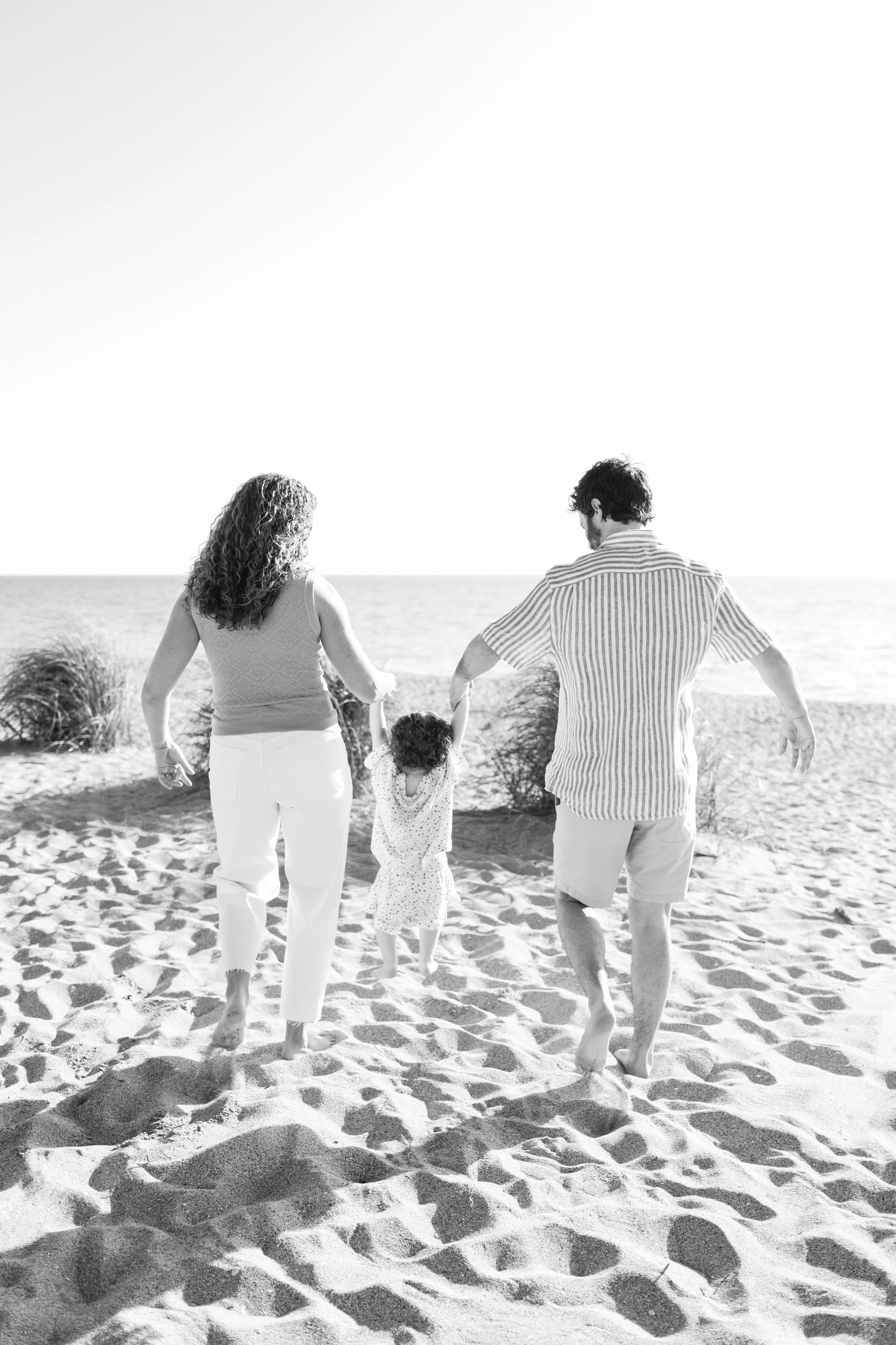 family-beach-photoshoot-venice-florida-walking-swinging-toddler-black-and-white.jpg