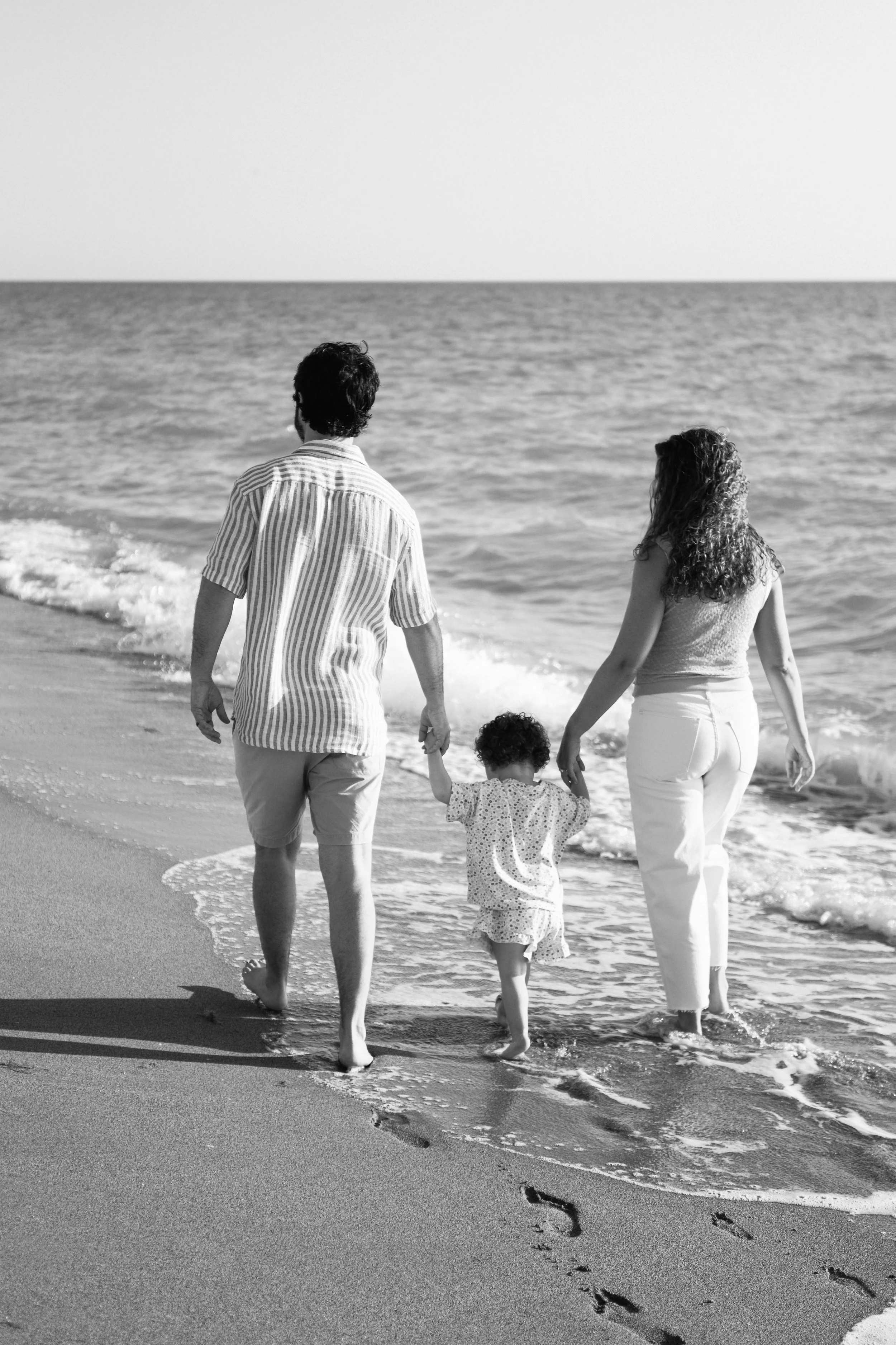 family-beach-photoshoot-venice-florida-walking-along-the-water-black-and-white2.jpg