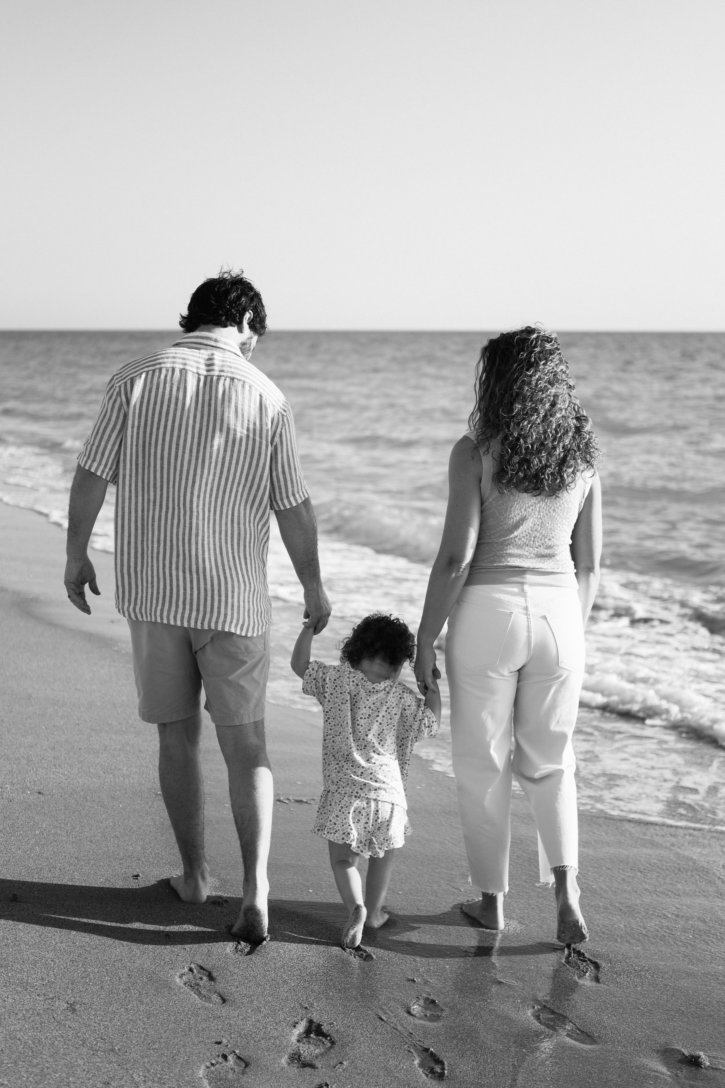 family-beach-photoshoot-venice-florida-walking-along-the-water-black-and-white.jpg