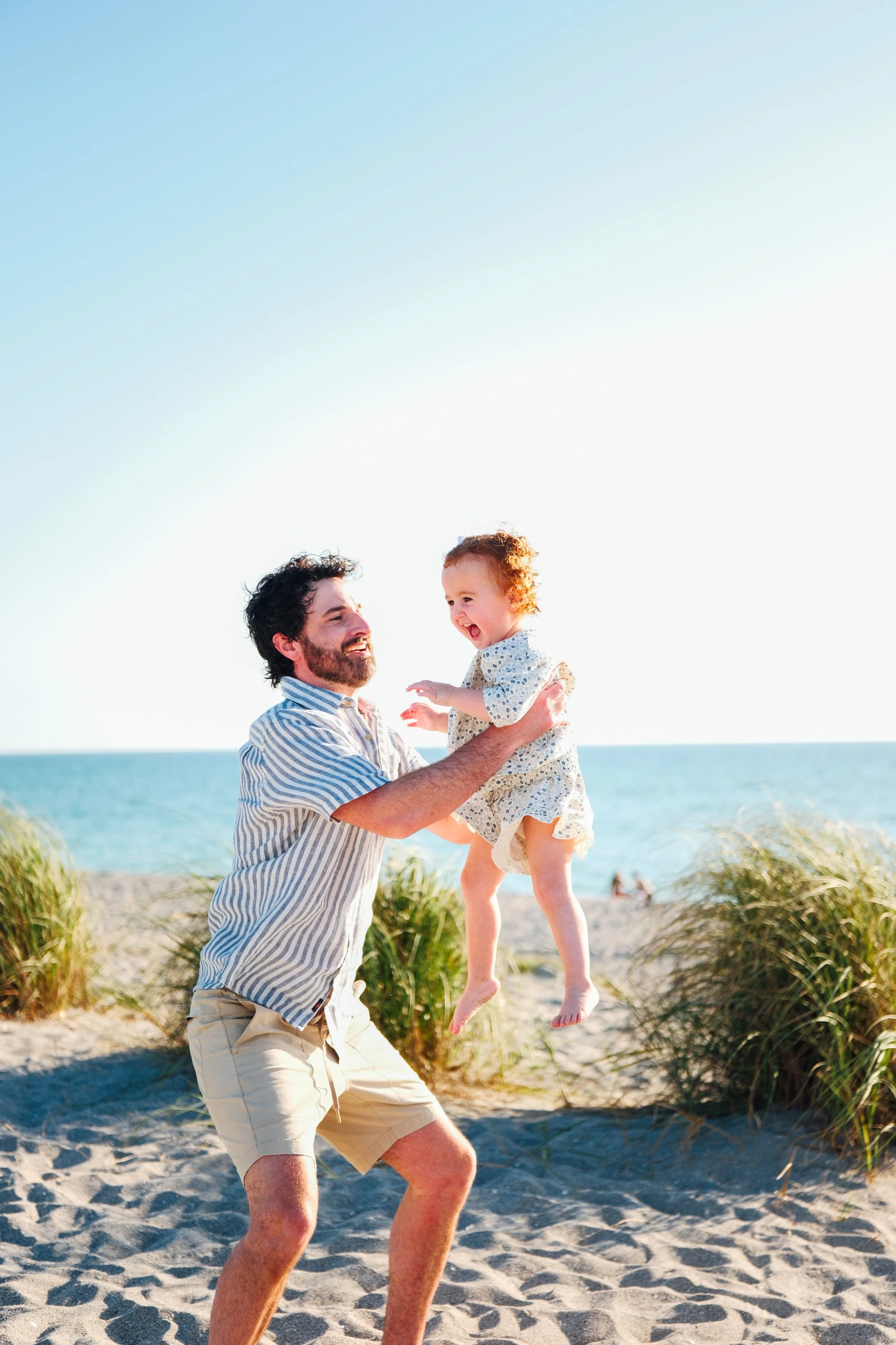 family-beach-photoshoot-venice-florida-dad-throwing-daughter.jpg
