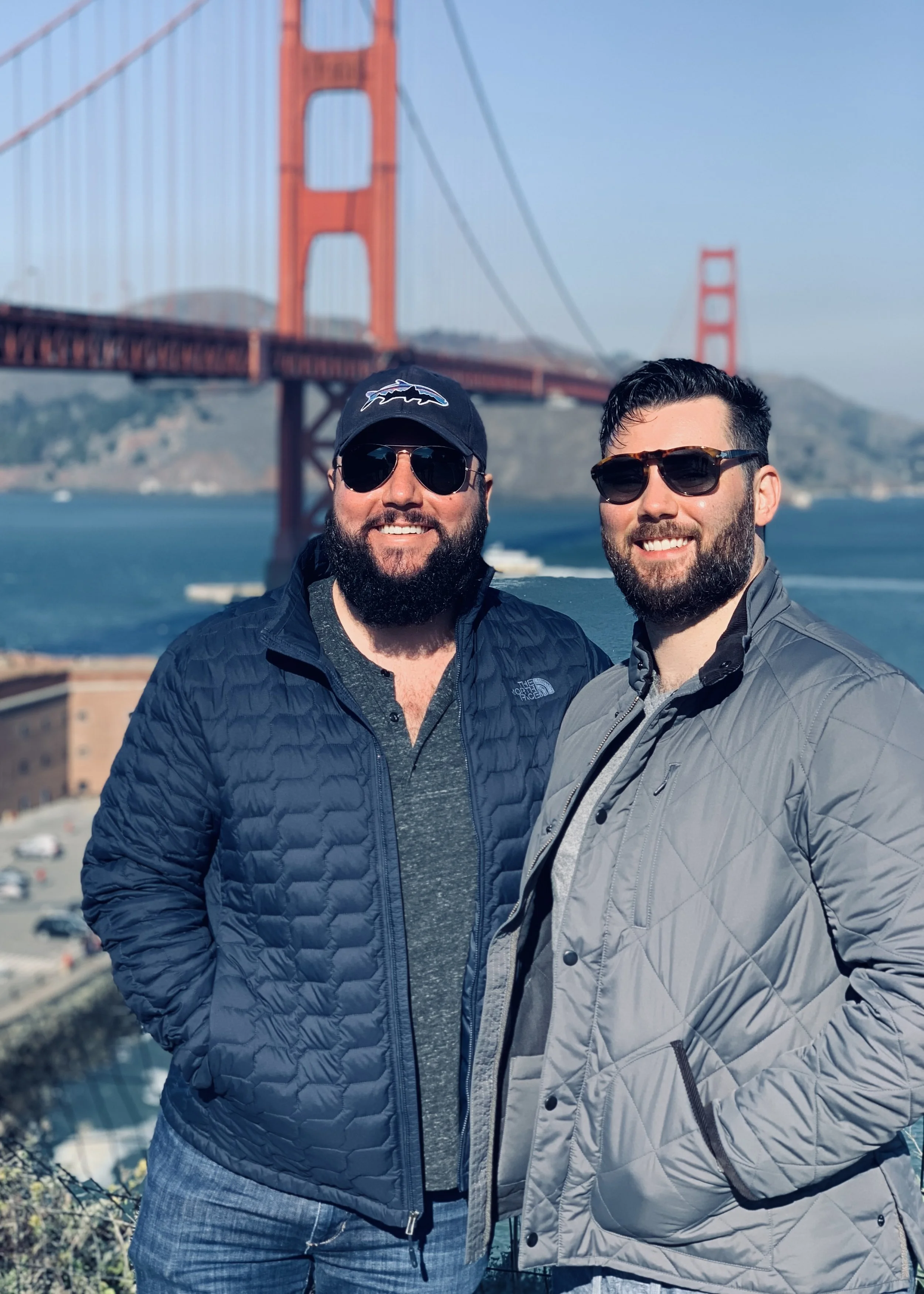 Laurie’s customers, Mariana and Carmen holding hands on a green lawn on their wedding day.