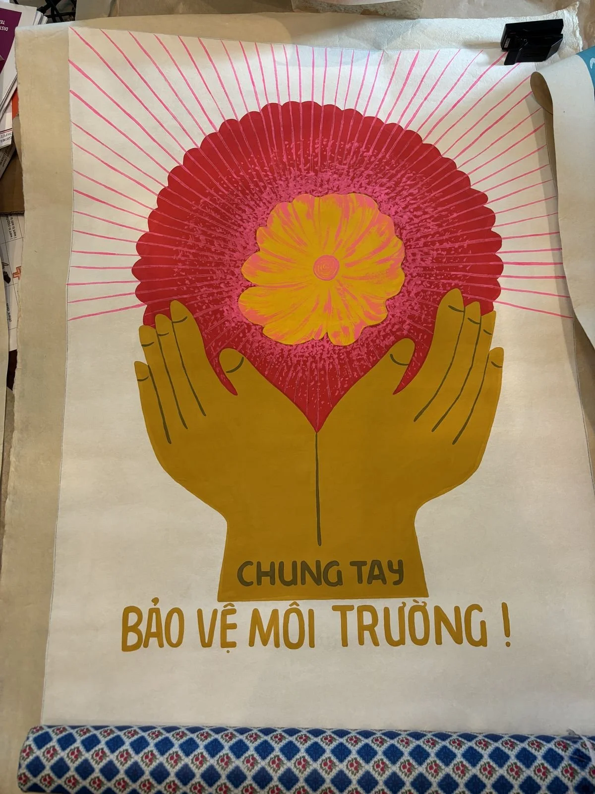A poster with illustrations of two hands holding a heart-shaped object containing a flower. The text on the poster reads 'Chung tay bảo vệ môi trường!'