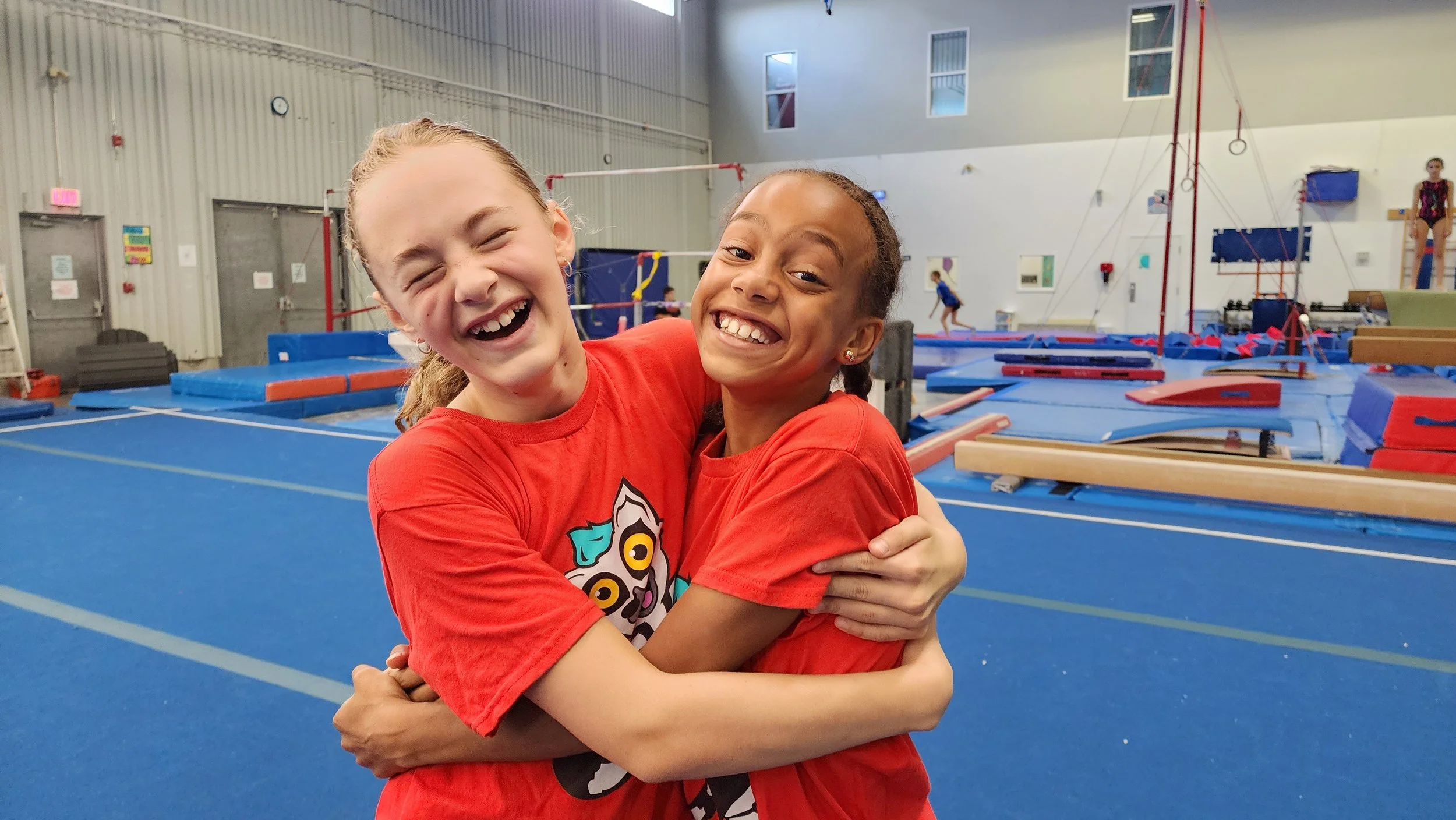 Two girls smiling and laughing at gymnastics camp in Ottawa