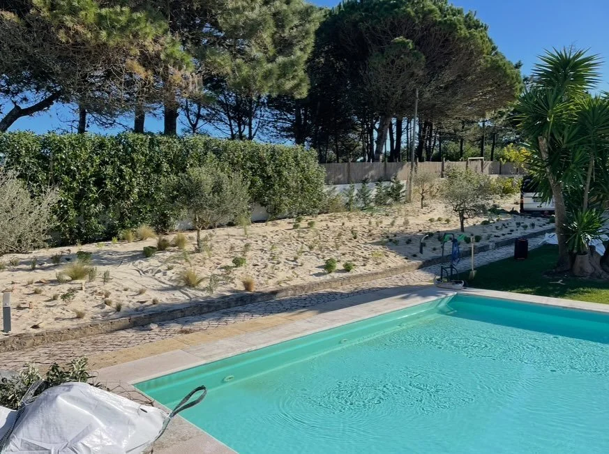 Out comes the thirsty thirsty lawn, in come the plants.

Lawn stripped, 100mm + of washed river sand (fines to 3mm) spread on top to help keep the limited water in the exsisting sandy topsoil, whilst reflecting the sunlight and keeping nice and coooo