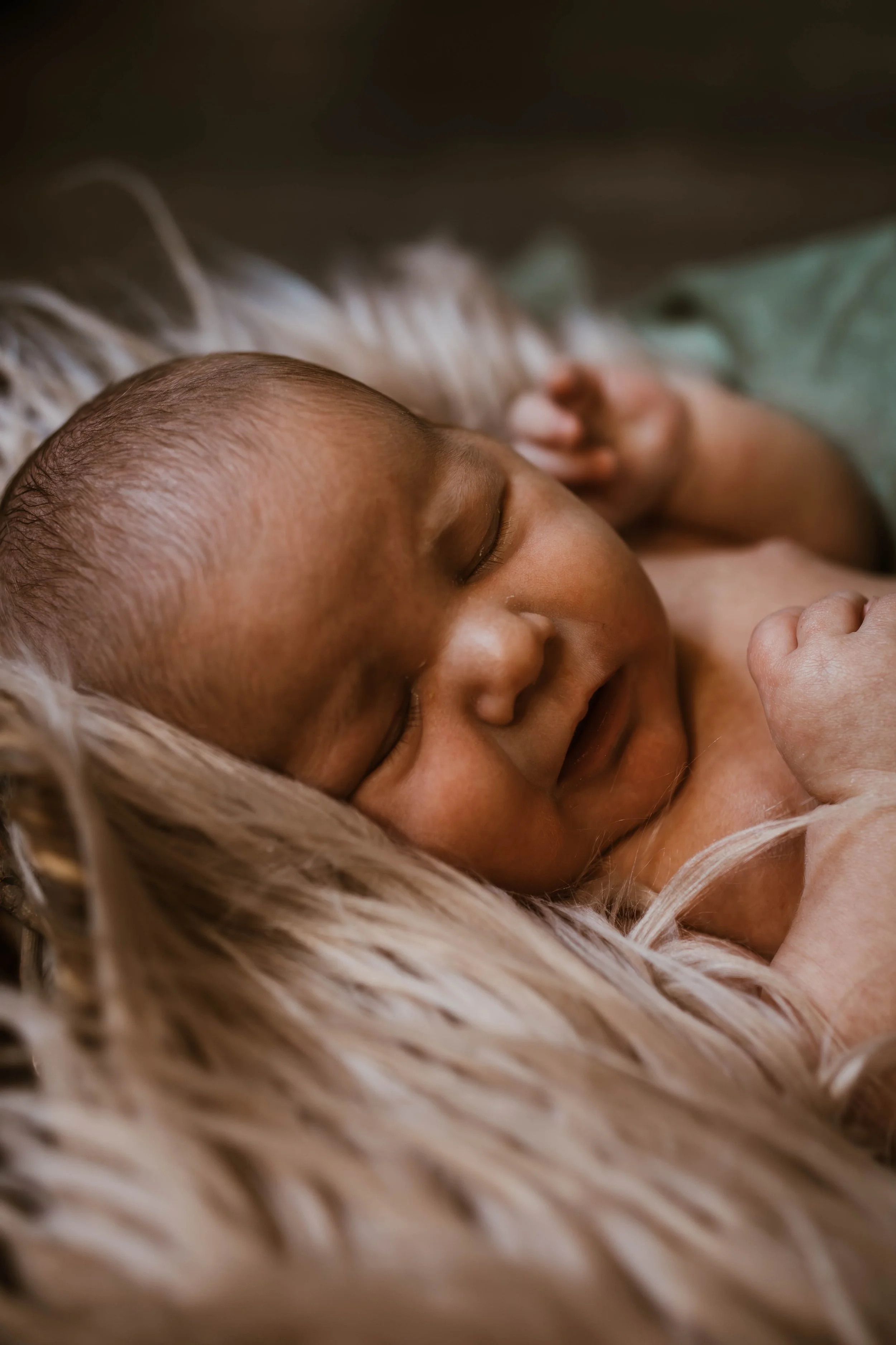Close-up of a smiling baby lying on a soft, furry blanket.