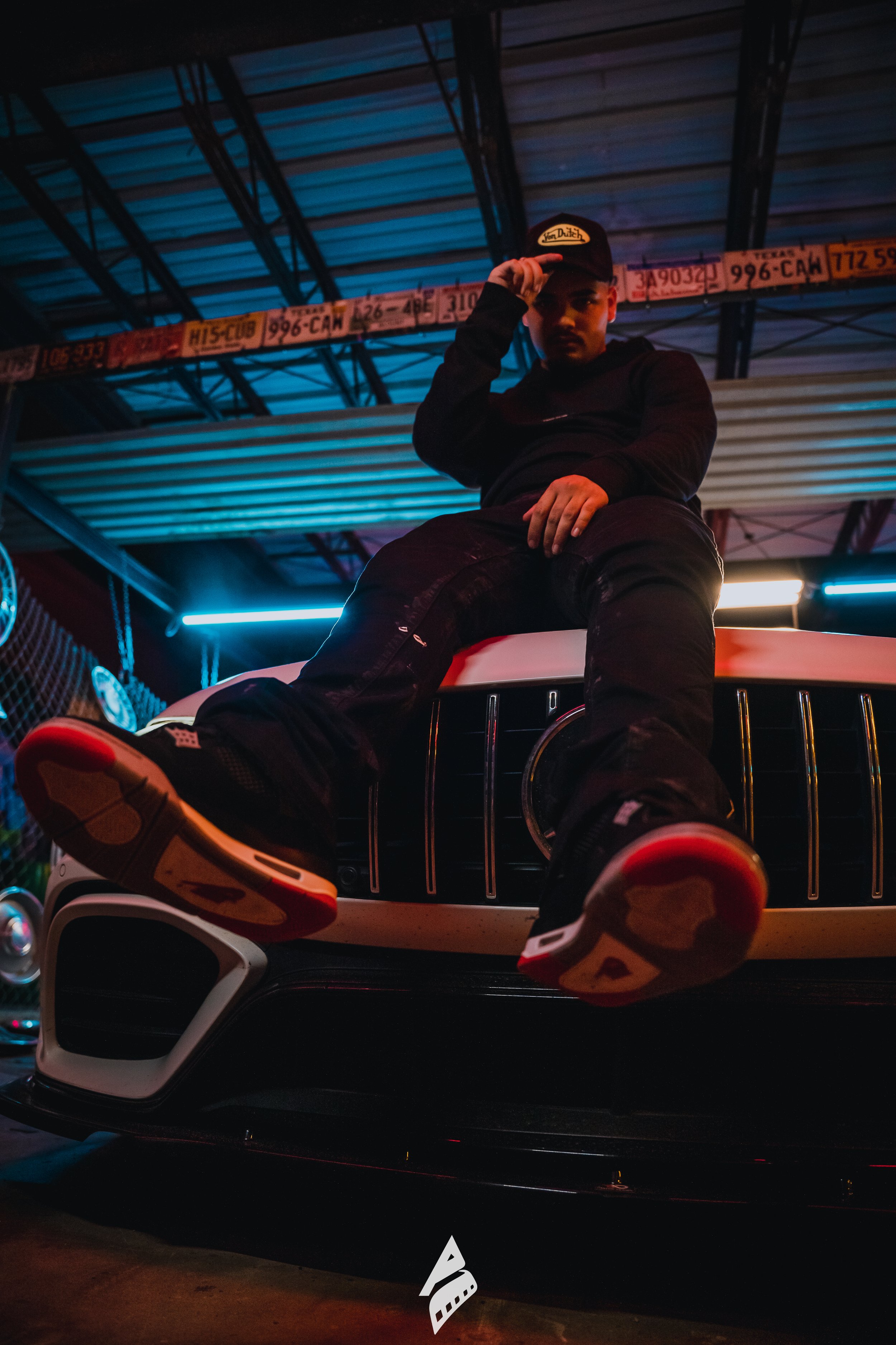 Artist seated on a red vehicle for an outdoor portrait.