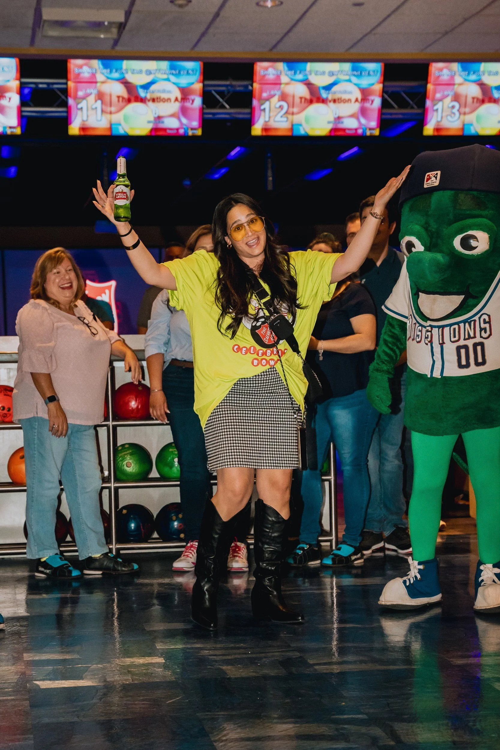 Cheering attendee beside a mascot.
