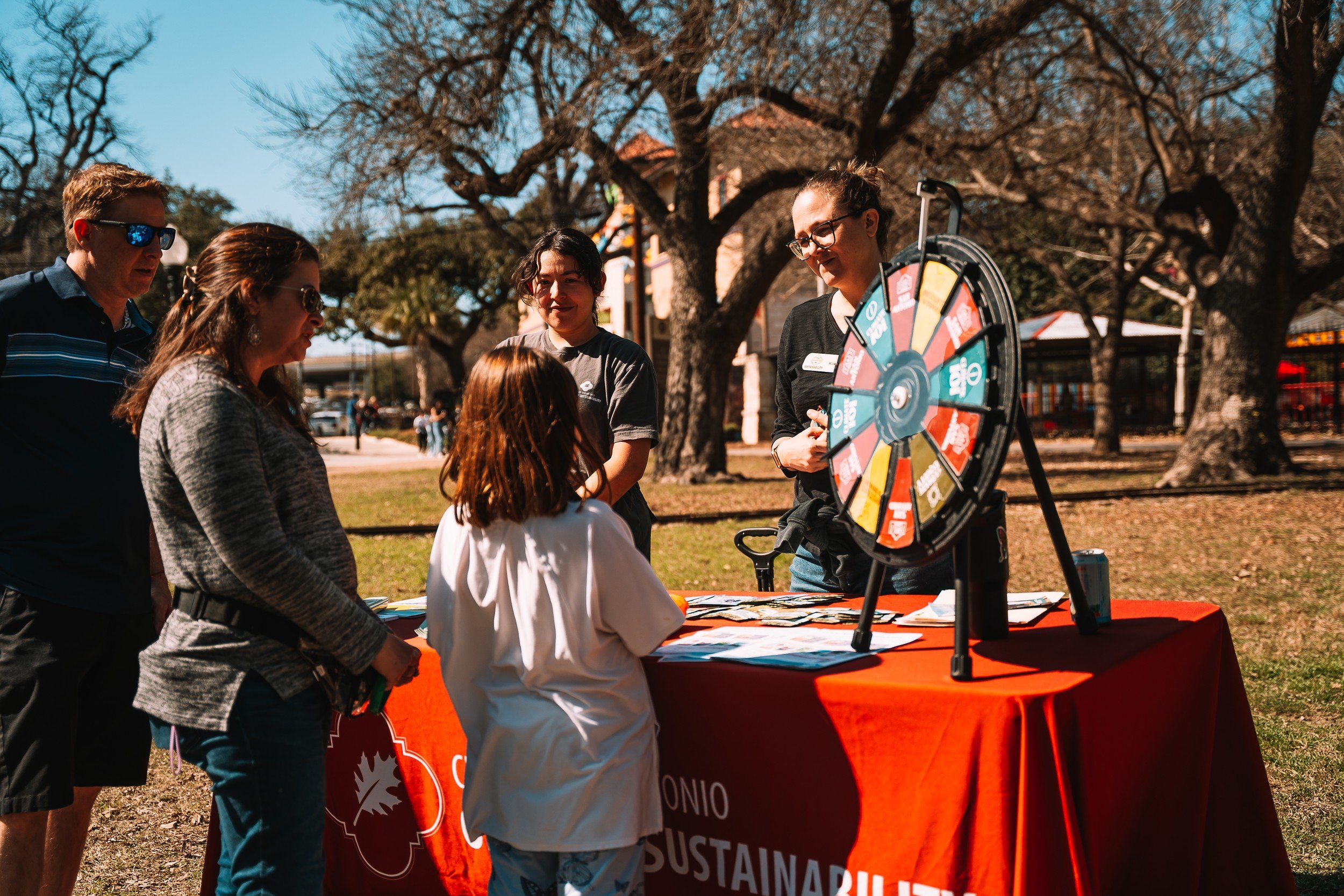 Visitors gathered around an activity wheel at the community event.