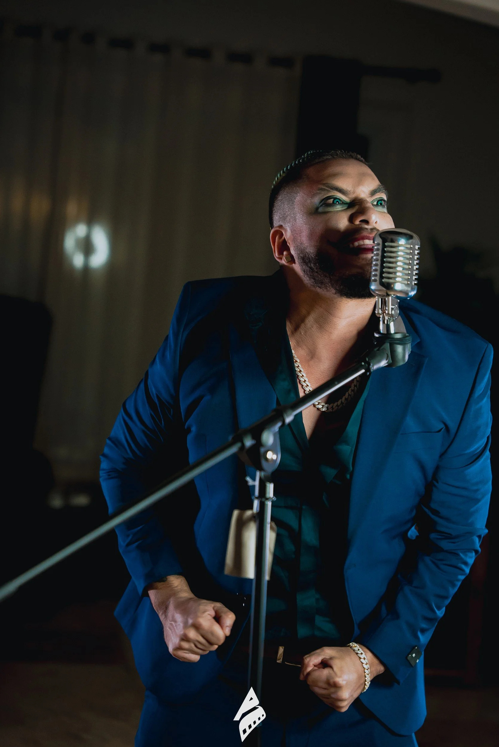 Performer in a blue suit holding a microphone.