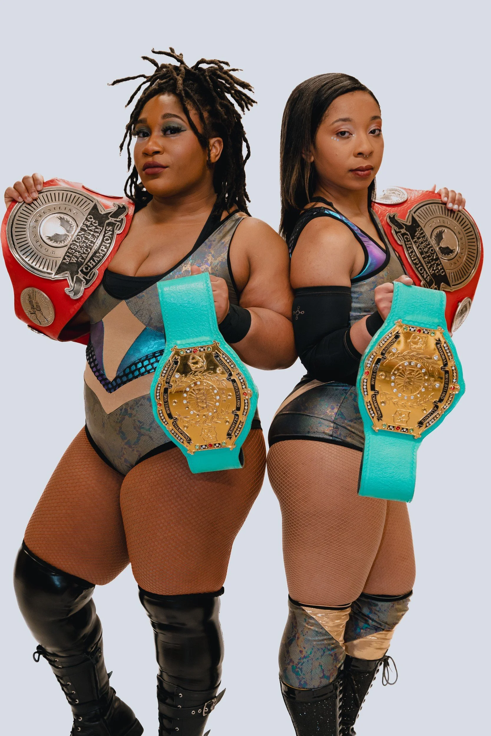 Two Mission Pro performers posing with championship belts.